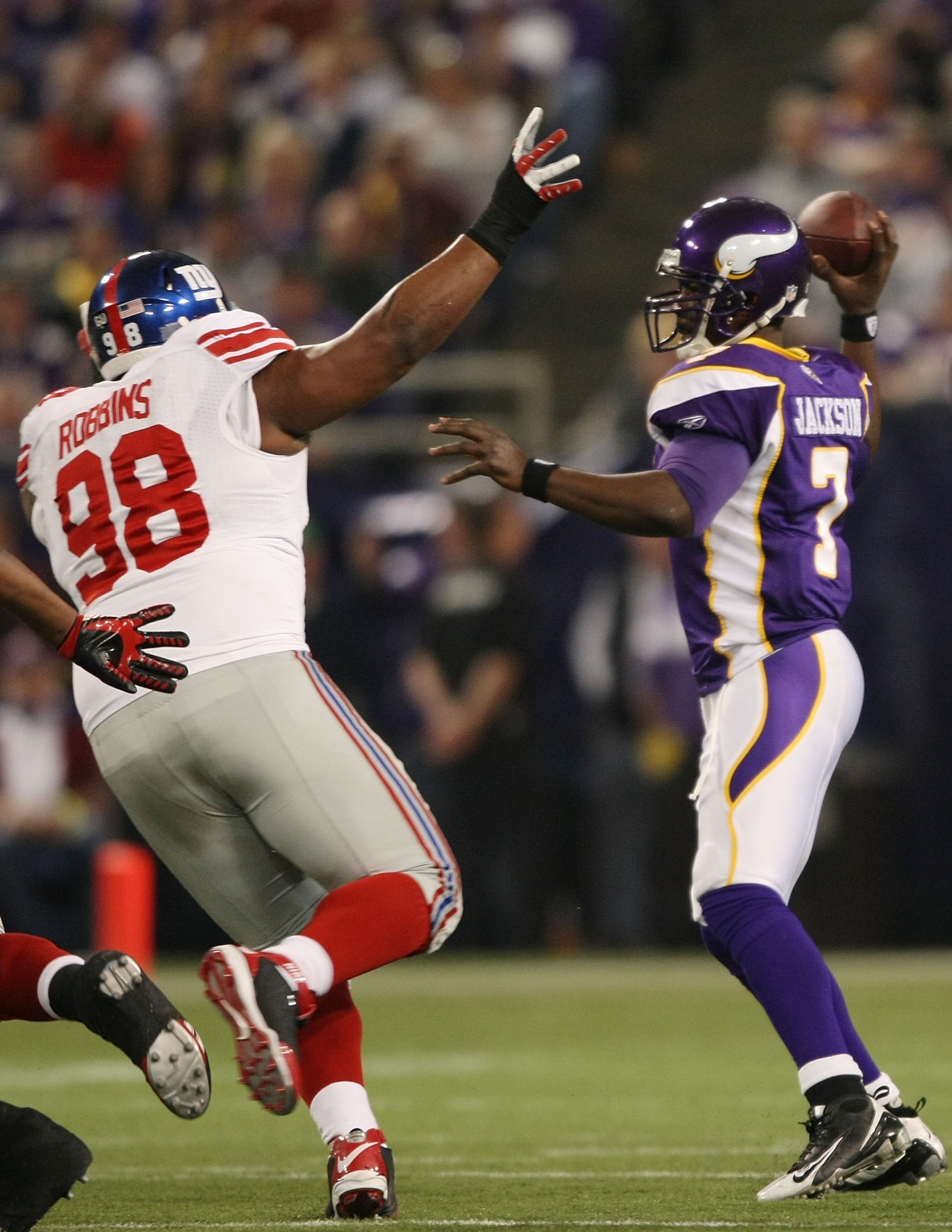 MINNEAPOLIS - DECEMBER 28:   Tarvaris Jackson #7 of the Minnesota Vikings passes under pressure from Fred Robbins #98 of the New York Giants on December 28, 2008 at the Hubert H. Humphrey Metrodome in Minneapolis, Minnesota. The Vikings defeated the Giant