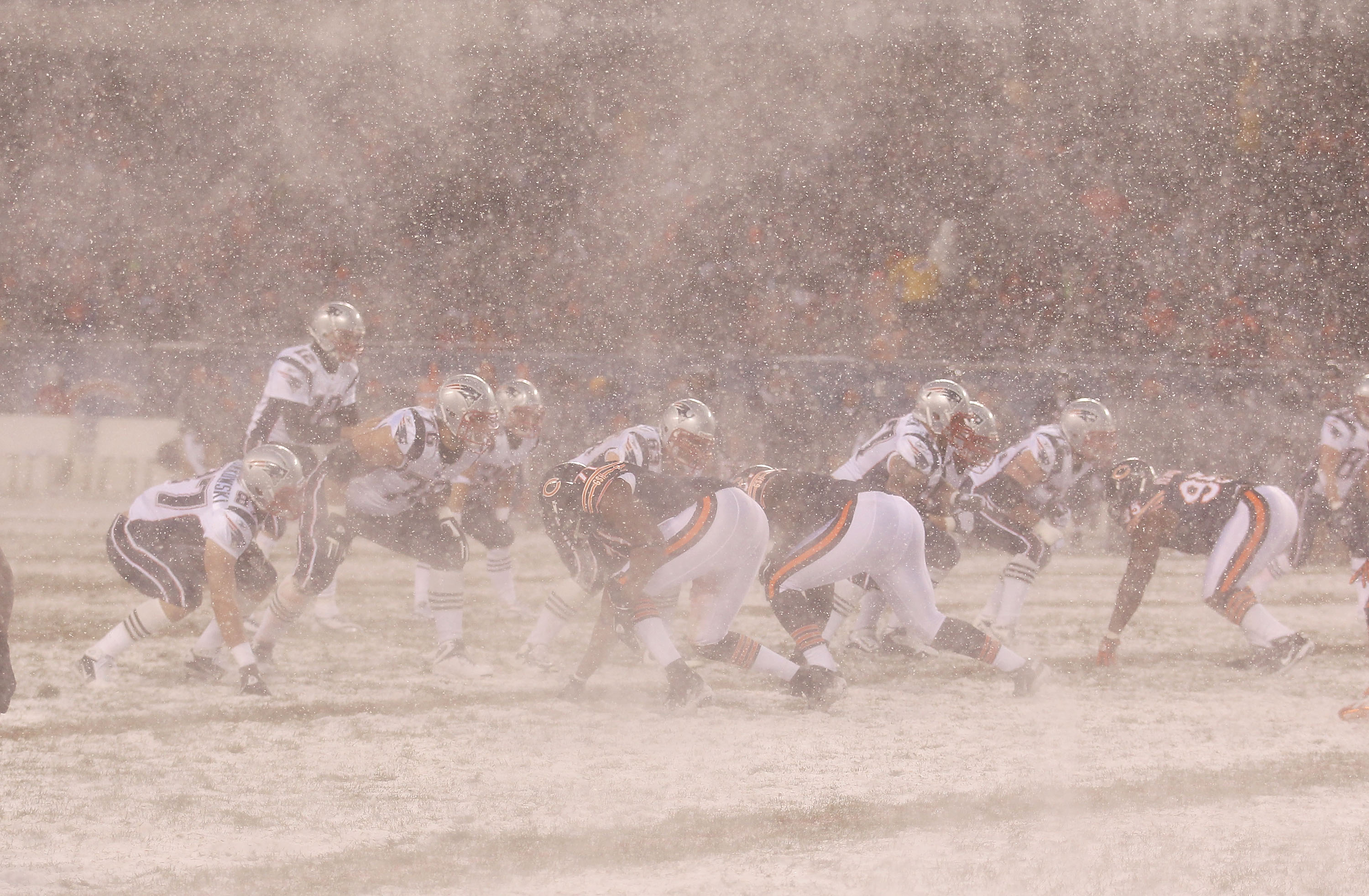 CHICAGO - DECEMBER 12: The wind swirls snow as Tom Brady #12 of the New England Patriots calls the signals against the Chicago Bearsat Soldier Field on December 12, 2010 in Chicago, Illinois. (Photo by Jonathan Daniel/Getty Images)