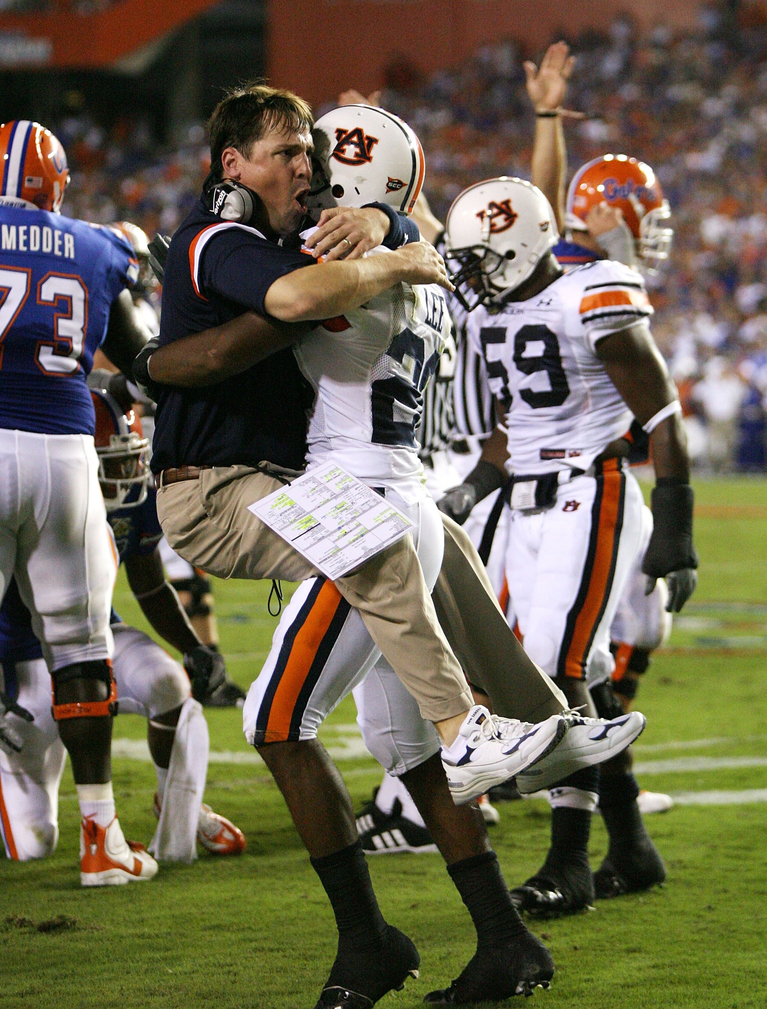 GAINESVILLE, FL - SEPTEMBER 29:  Defensive coordinator Will Muschamp of the Auburn Tigers jumps into the arms of defensive back Patrick Lee #20 after Lee helped cause a fumble late in the first half against the Florida Gators at Ben Hill Griffin Stadium S