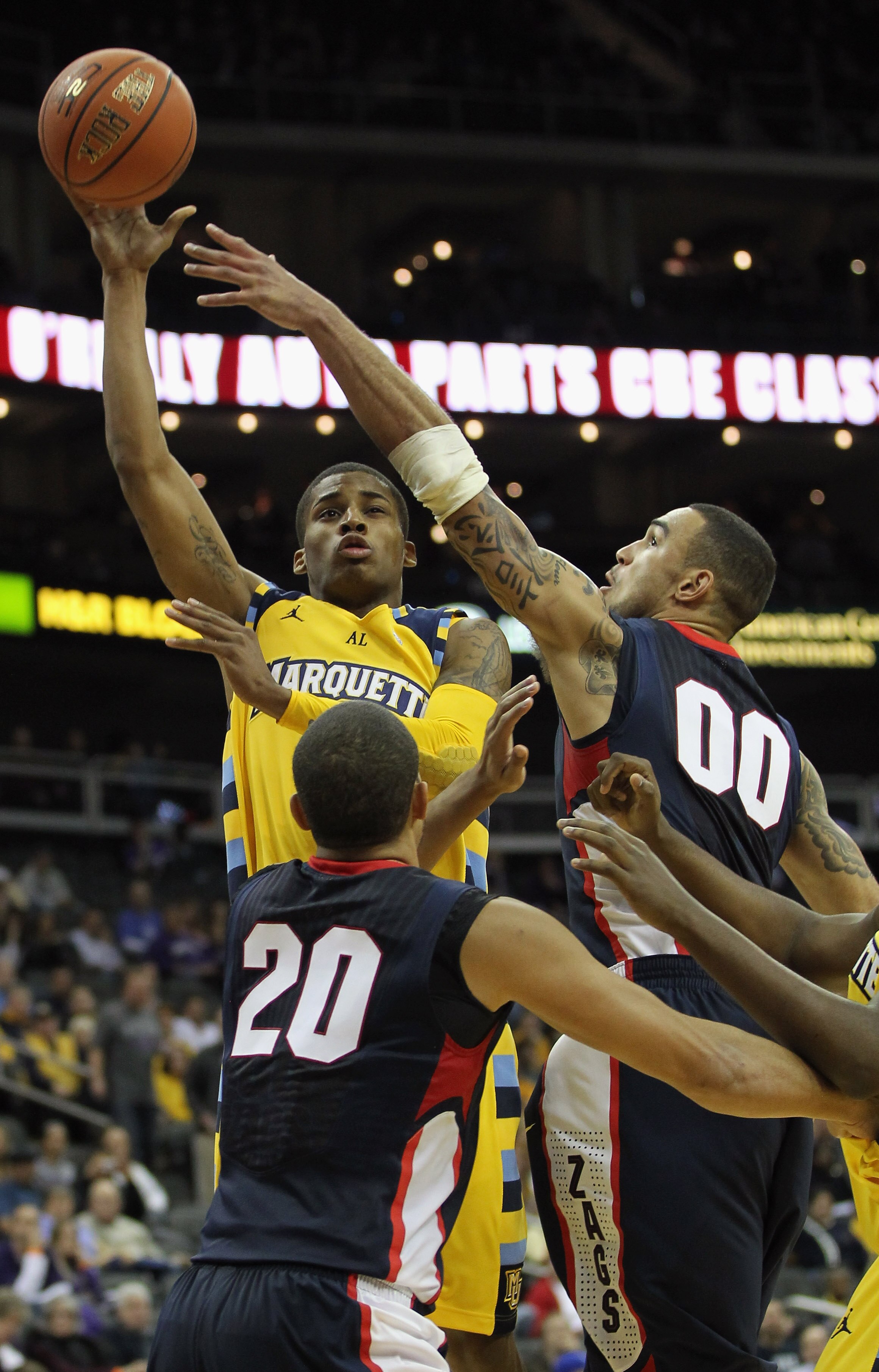 KANSAS CITY, MO - NOVEMBER 23:  Vander Blue #2 of the Marquette Golden Eagles shoots over Elias Harris #20 and Robert Sacre #00 of the Gonzaga Bulldogs during the CBE Classic consolation game on November 23, 2010 at the Sprint Center in Kansas City, Misso
