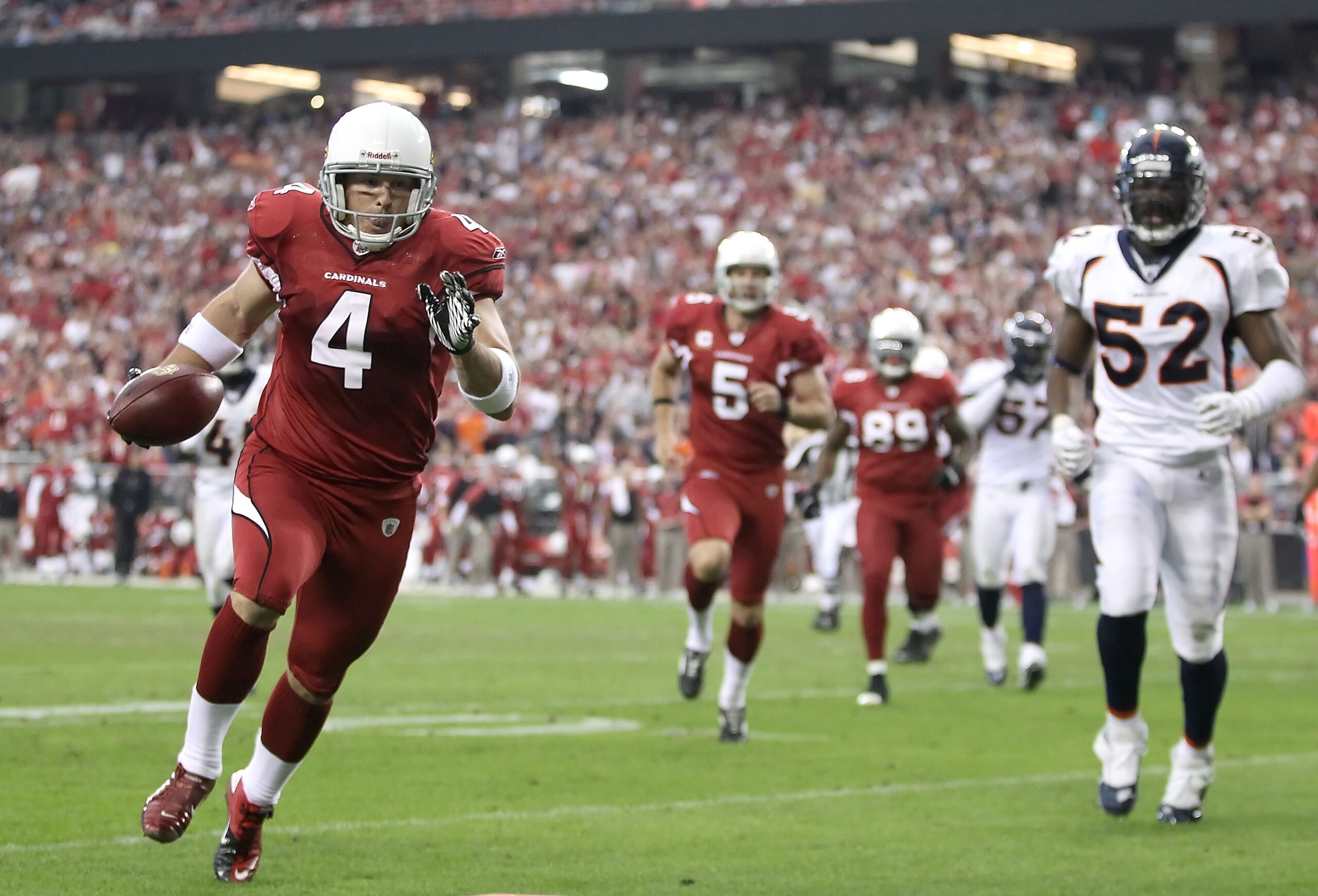 GLENDALE, AZ - DECEMBER 12:  Place kicker Jay Feely #4 of the Arizona Cardinals runs with the football for a 5 yard rushing touchdown past Jason Hunter #52 of the Denver Broncos during the second quarter of the NFL game at the University of Phoenix Stadiu