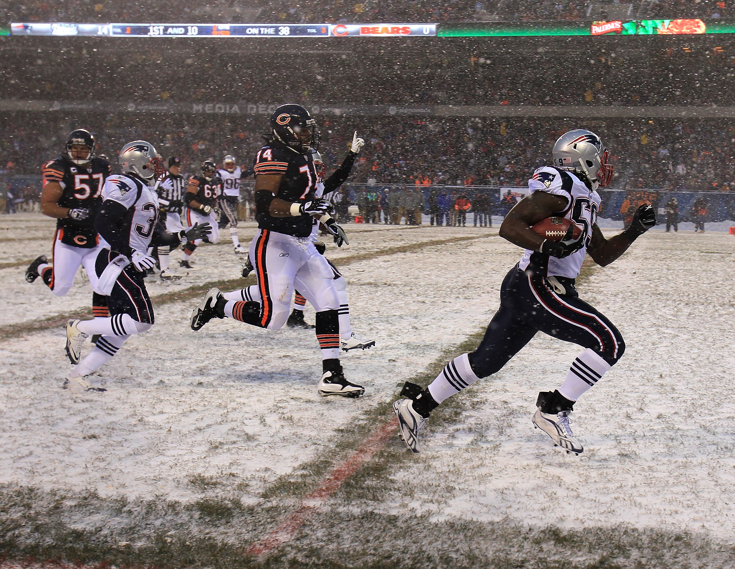 CHICAGO - DECEMBER 12: Gary Guyton #59 of the New England Patriots runs for a touchdown after picking up a fumble as Chris Williams #74 and Olin Kreutz #57 of the Chicago Bears pursue at Soldier Field on December 12, 2010 in Chicago, Illinois. (Photo by J