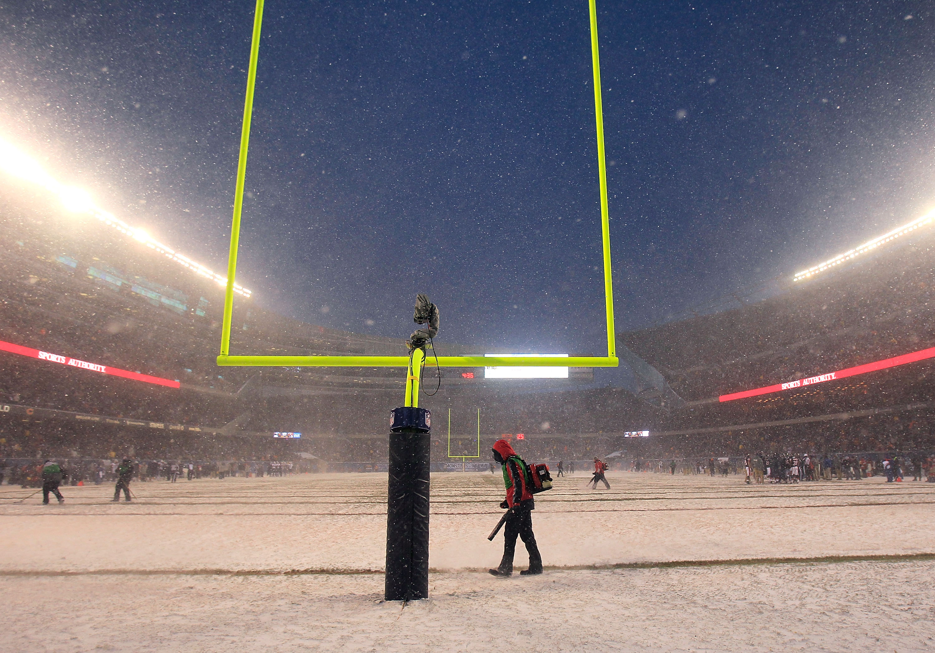 CHICAGO, IL - DECEMBER 12: Workers clear the yard markers during a time-out of a game between the Chicago Bears and the New England Patriots at Soldier Field on December 12, 2010 in Chicago, Illinois. The Patriots defeated the Bears 36-7. (Photo by Jonath