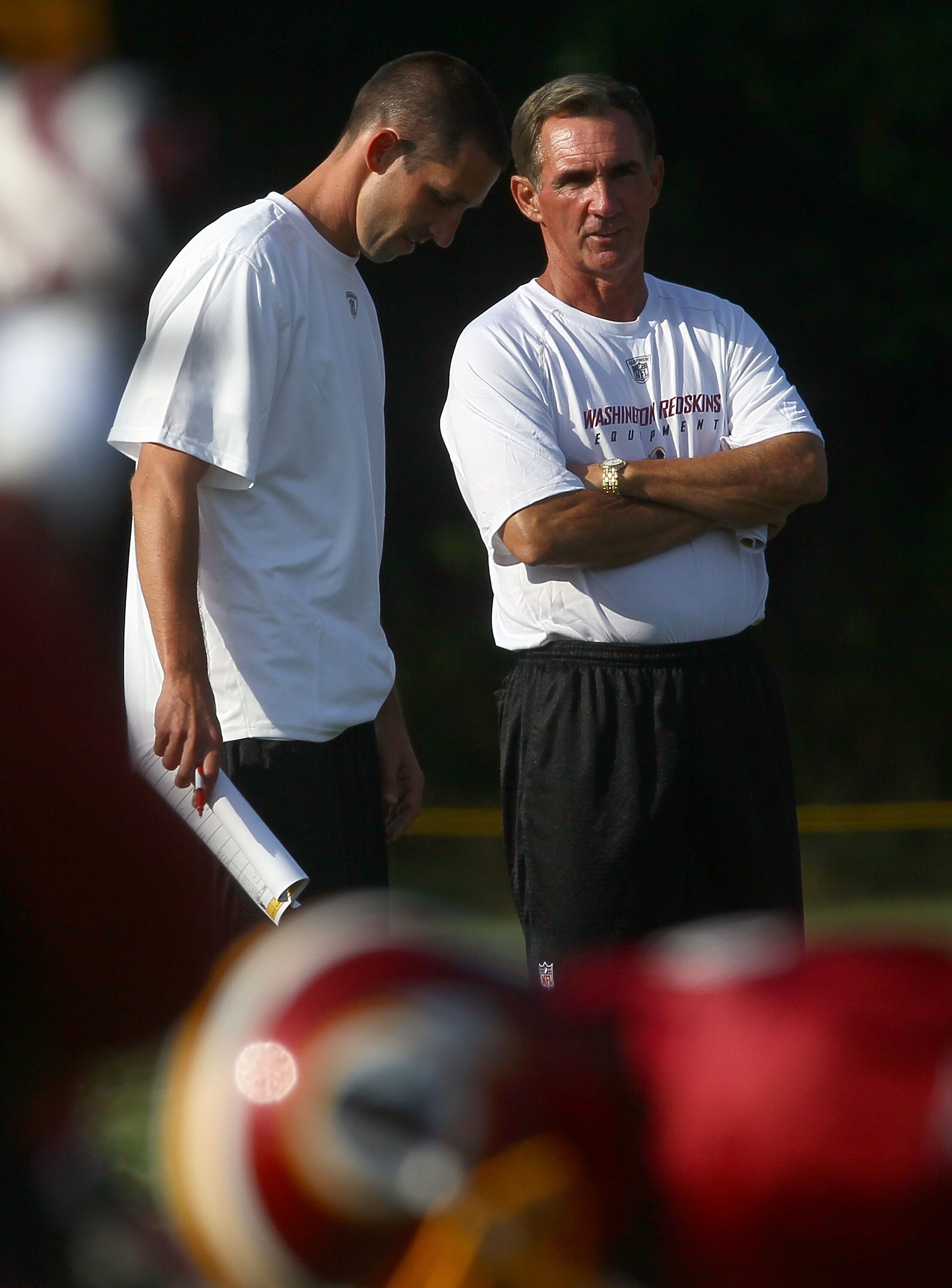 ASHBURN, VA - JULY 30:  Head coach Mike Shanahan (R) of the Washington Redskins speaks with his son and offensive coordinator, Kyle Shanahan (L), during the second day of training camp July 30, 2010 in Ashburn, Virginia.  (Photo by Win McNamee/Getty Image