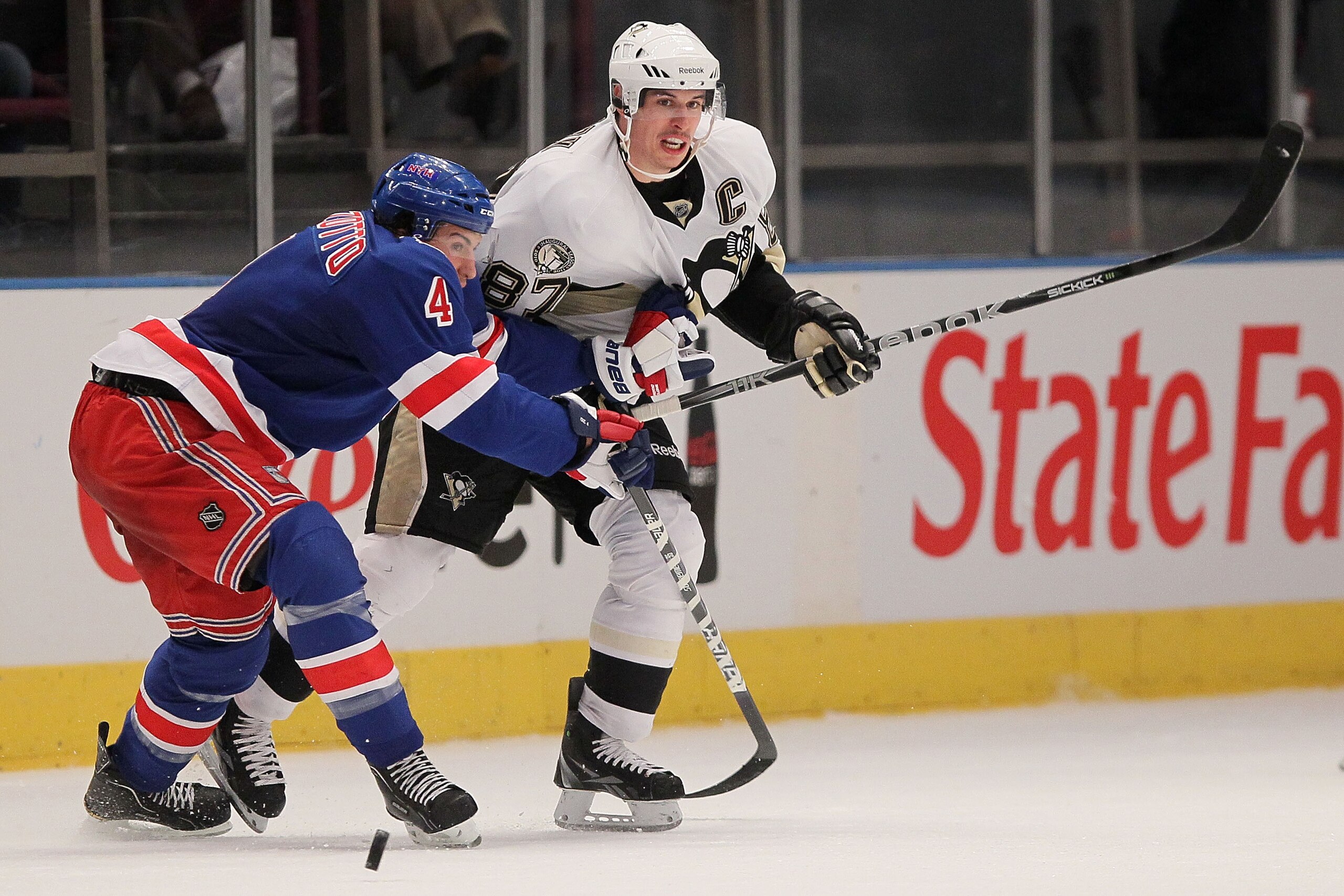 NEW YORK, NY - NOVEMBER 29:  Sidney Crosby #87 of the Pittsburgh Penguins chases the puck against Michael Del Zotto #4 of the New York Rangers during their game on November 29, 2010 at Madison Square Garden in New York City.  (Photo by Chris McGrath/Getty