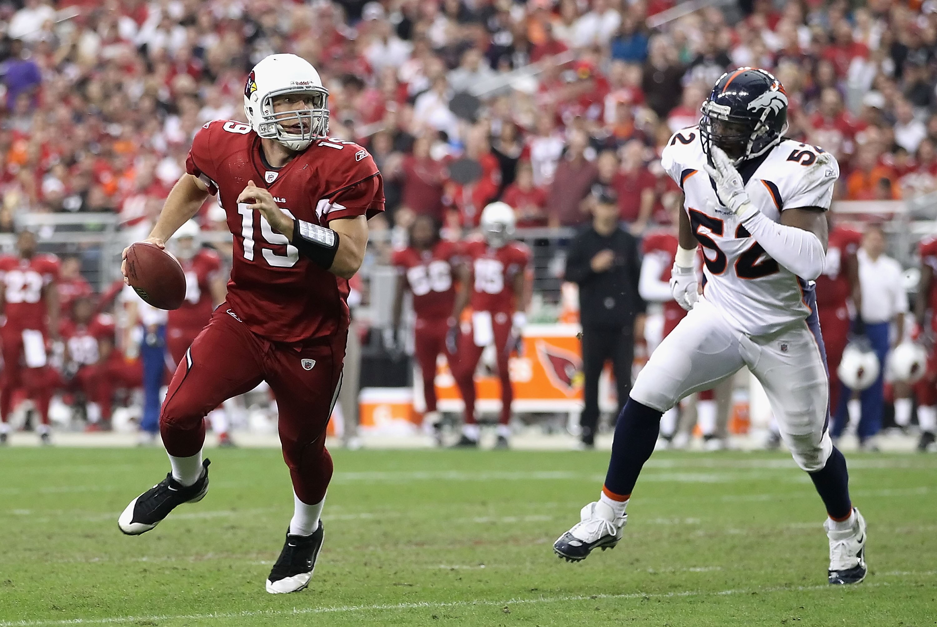 GLENDALE, AZ - DECEMBER 12:  Quarterback John Skelton #19 of the Arizona Cardinals scrambles with the football under pressure from Jason Hunter #52 of the Denver Broncos during the NFL game at the University of Phoenix Stadium on December 12, 2010 in Glen