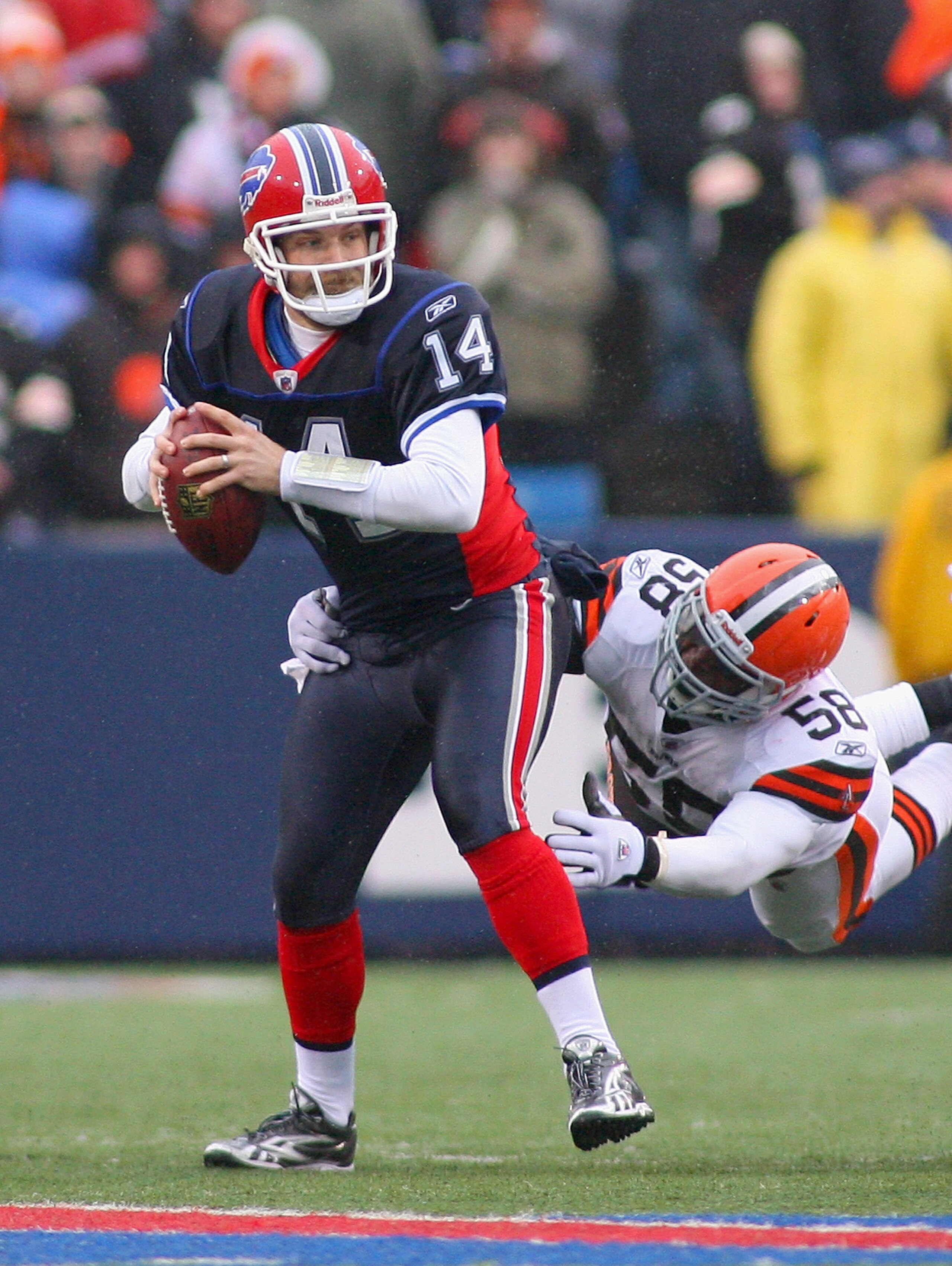 ORCHARD PARK, NY - DECEMBER 12:  Ryan Fitzpatrick #14 of the Buffalo Bills looks to pass with pressure from Marcus Benard #58 of the Cleveland Browns at Ralph Wilson Stadium on December 12, 2010 in Orchard Park, New York. Buffalo won 13-6.  (Photo by Rick