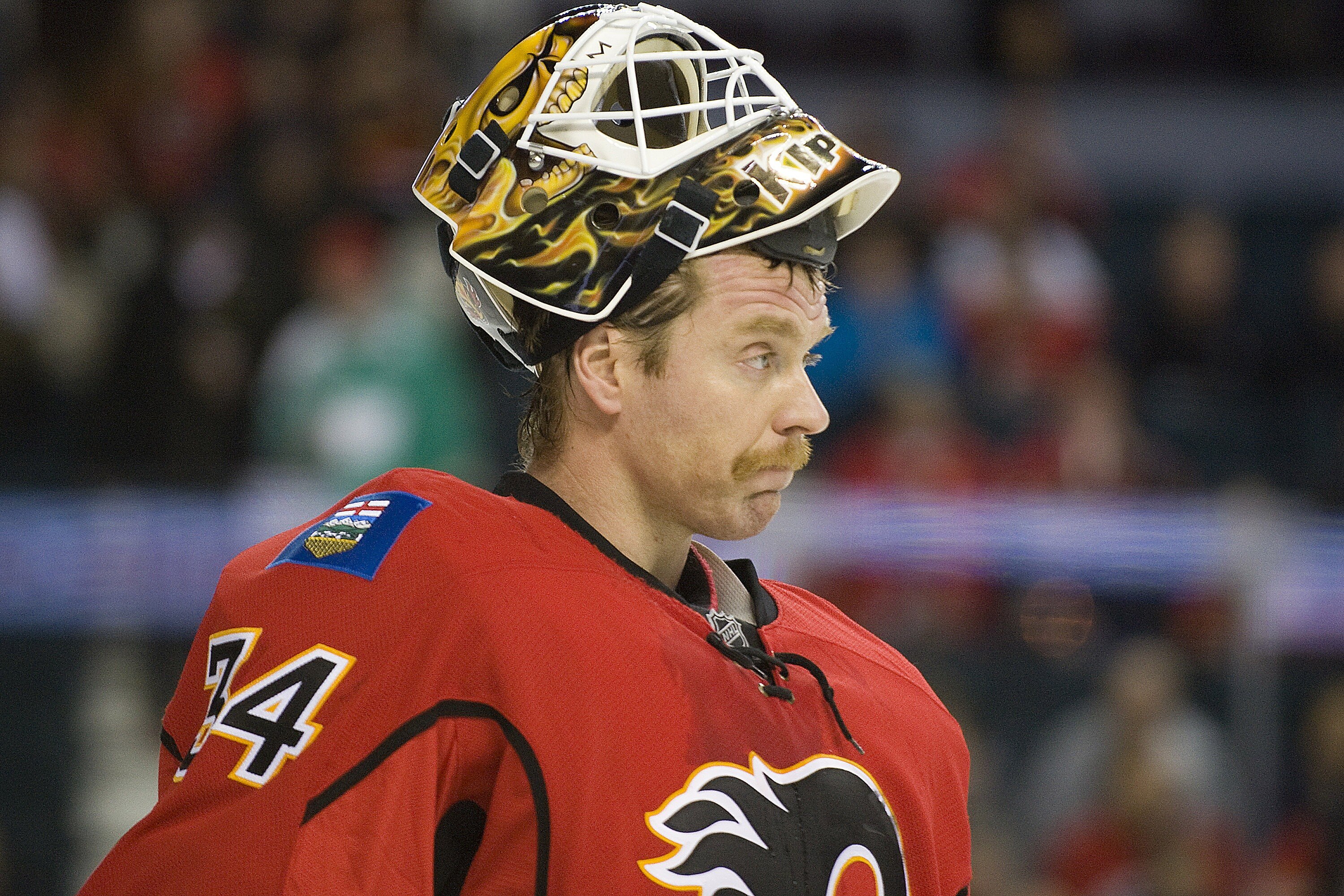 EDMONTON, AB - NOVEMBER 29:  Miikka Kiprusoff #34 of the Calgary Flames lifts his mask during a stoppage against the Minnesota Wild at Scotiabank Saddledome on November 29, 2010 in Calgary, Alberta, Canada. The Flames beat the Wild 3-0.  (Photo by Dylan L