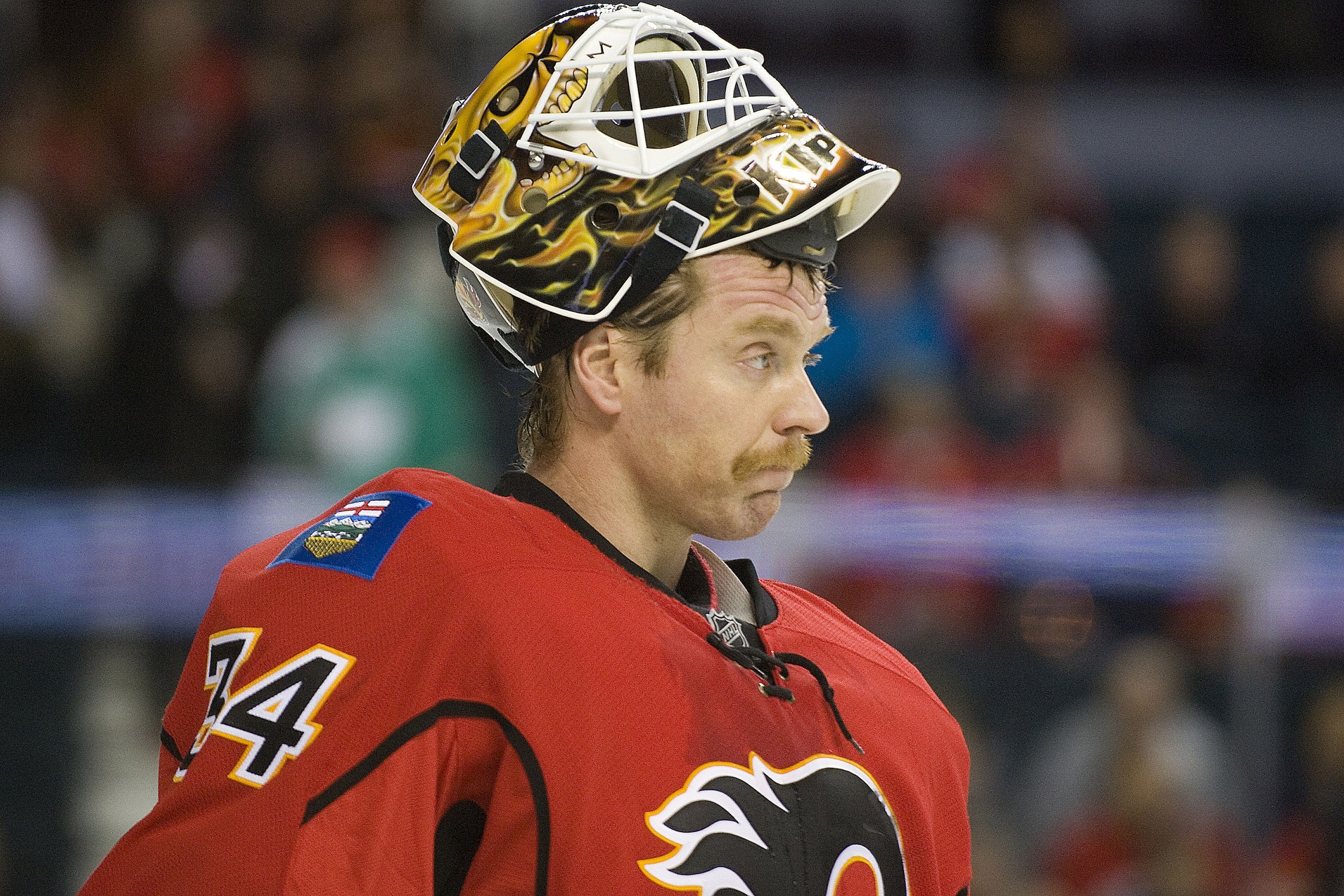 EDMONTON, AB - NOVEMBER 29:  Miikka Kiprusoff #34 of the Calgary Flames lifts his mask during a stoppage against the Minnesota Wild at Scotiabank Saddledome on November 29, 2010 in Calgary, Alberta, Canada. The Flames beat the Wild 3-0.  (Photo by Dylan L