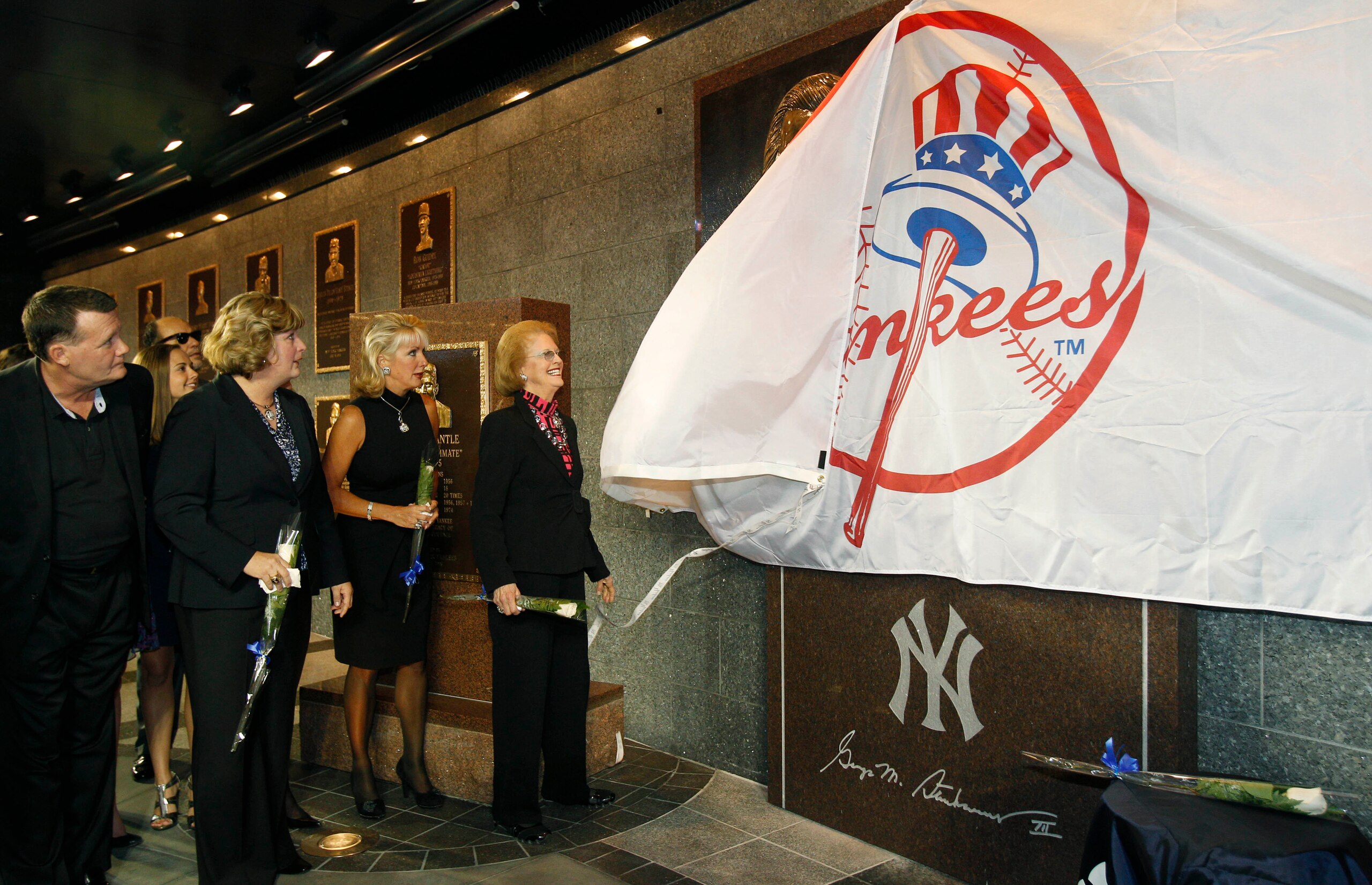 NEW YORK - SEPTEMBER 20:  Members of the Steinbrenner family watch as Steinbrenner's widow Joan pulls a Yankees banner down to reveal  a monument to the late Yankees principal owner George Steinbrenner during a dedication ceremony before the Yankees baseb