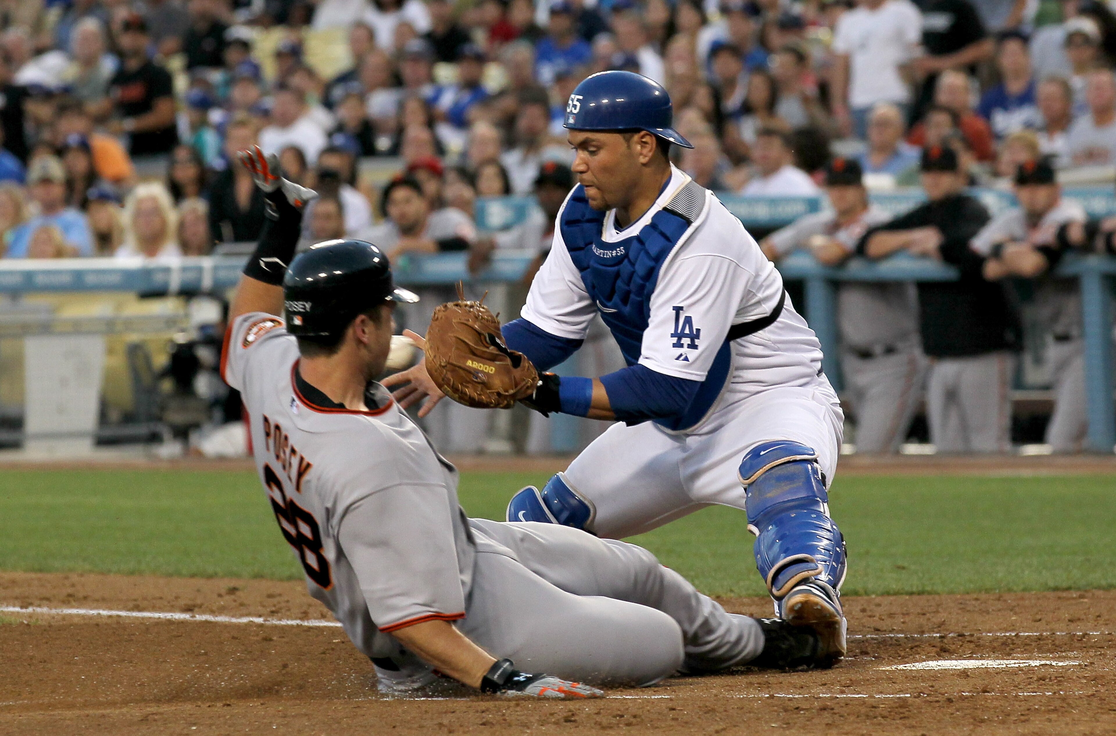 LOS ANGELES - JULY 19: Buster Posey #28 of the San Francisco Giants slides safely into home with a run as catcher Russell Martin #55 of the Los Angeles Dodgers takes the throw in the third inning on July 19, 2010 at Dodger Stadium in Los Angeles, Califor LOS ANGELES - JULY 19: Buster Posey #28 of the San Francisco Giants slides safely into home with a run as catcher Russell Martin #55 of the Los Angeles Dodgers takes the throw in the third inning on July 19, 2010 at Dodger Stadium in Los Angeles, Califor