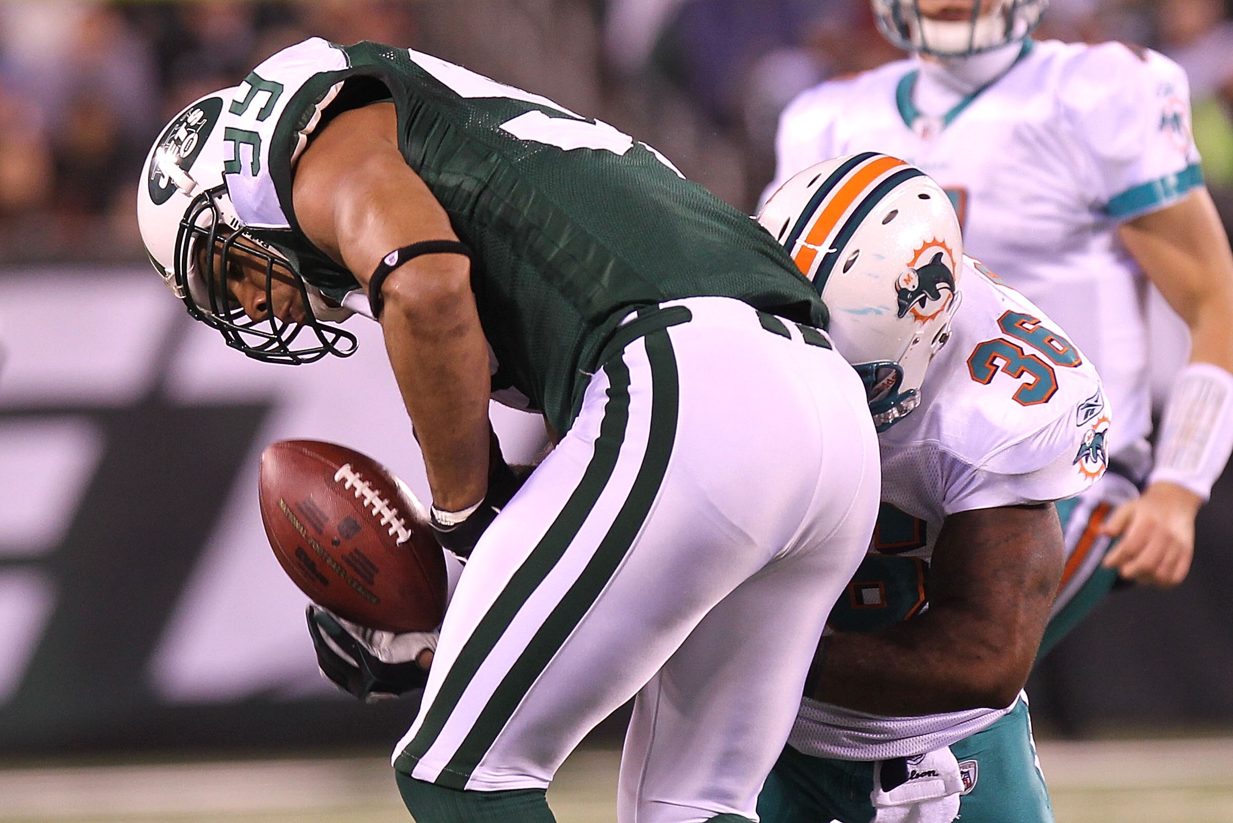 EAST RUTHERFORD, NJ - DECEMBER 12: Jason Taylor #99 of the New York Jets has a possible interception broken up by Lousaka Polite #36 of the Miami Dolphins at New Meadowlands Stadium on December 12, 2010 in East Rutherford, New Jersey.  (Photo by Nick Laha