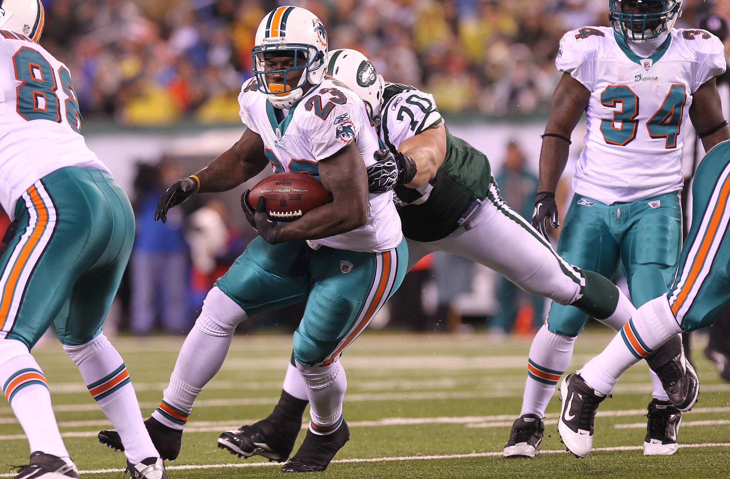 EAST RUTHERFORD, NJ - DECEMBER 12:  Ronnie Brown #23 of the Miami Dolphins is tackled by Mike DeVito #70 of the New York Jets at New Meadowlands Stadium on December 12, 2010 in East Rutherford, New Jersey.  (Photo by Nick Laham/Getty Images)