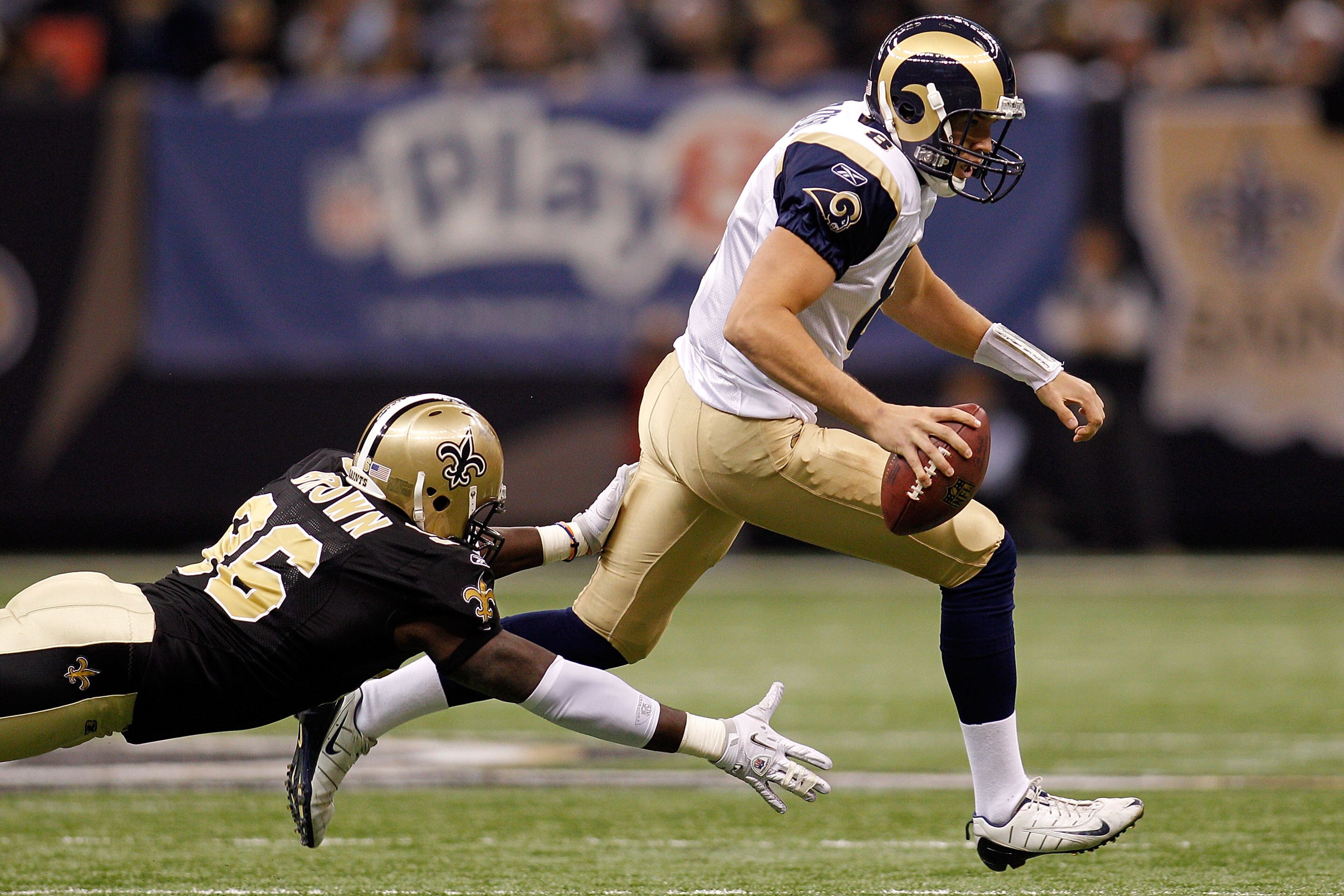 NEW ORLEANS, LA - DECEMBER 12:  Quarterback Sam Bradford #8 of the St. Louis Rams avoids a tackle by Alex Brown #96 of the New Orleans Saints at the Louisiana Superdome on December 12, 2010 in New Orleans, Louisiana.  (Photo by Chris Graythen/Getty Images