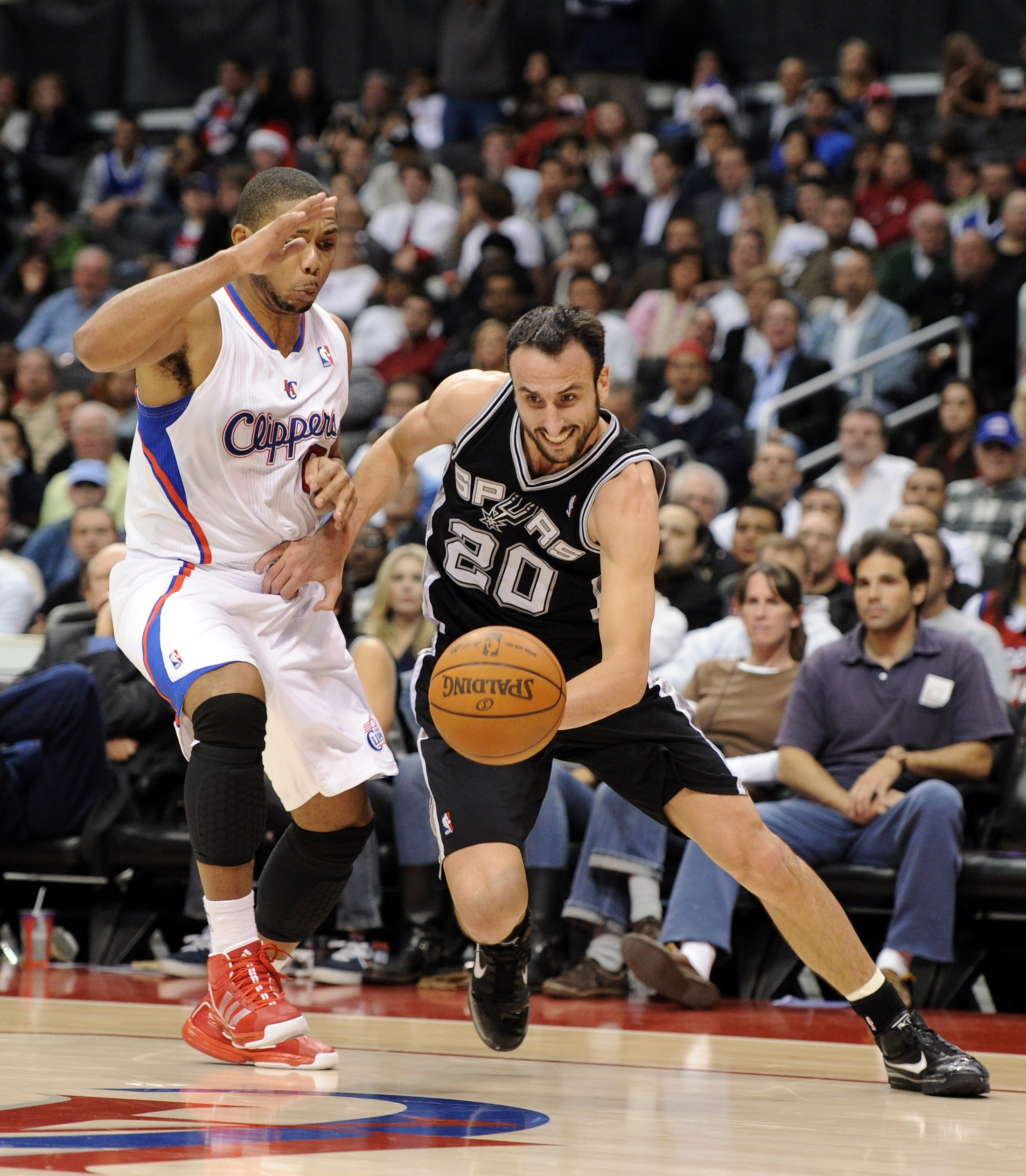 LOS ANGELES, CA - DECEMBER 01:  Manu Ginobili #20 of the San Antonio Spurs drives dribbles around Eric Gordon #10 of the Los Angeles Clippers during the game at the Staples Center on December 1, 2010 in Los Angeles, California.  NOTE TO USER: User express