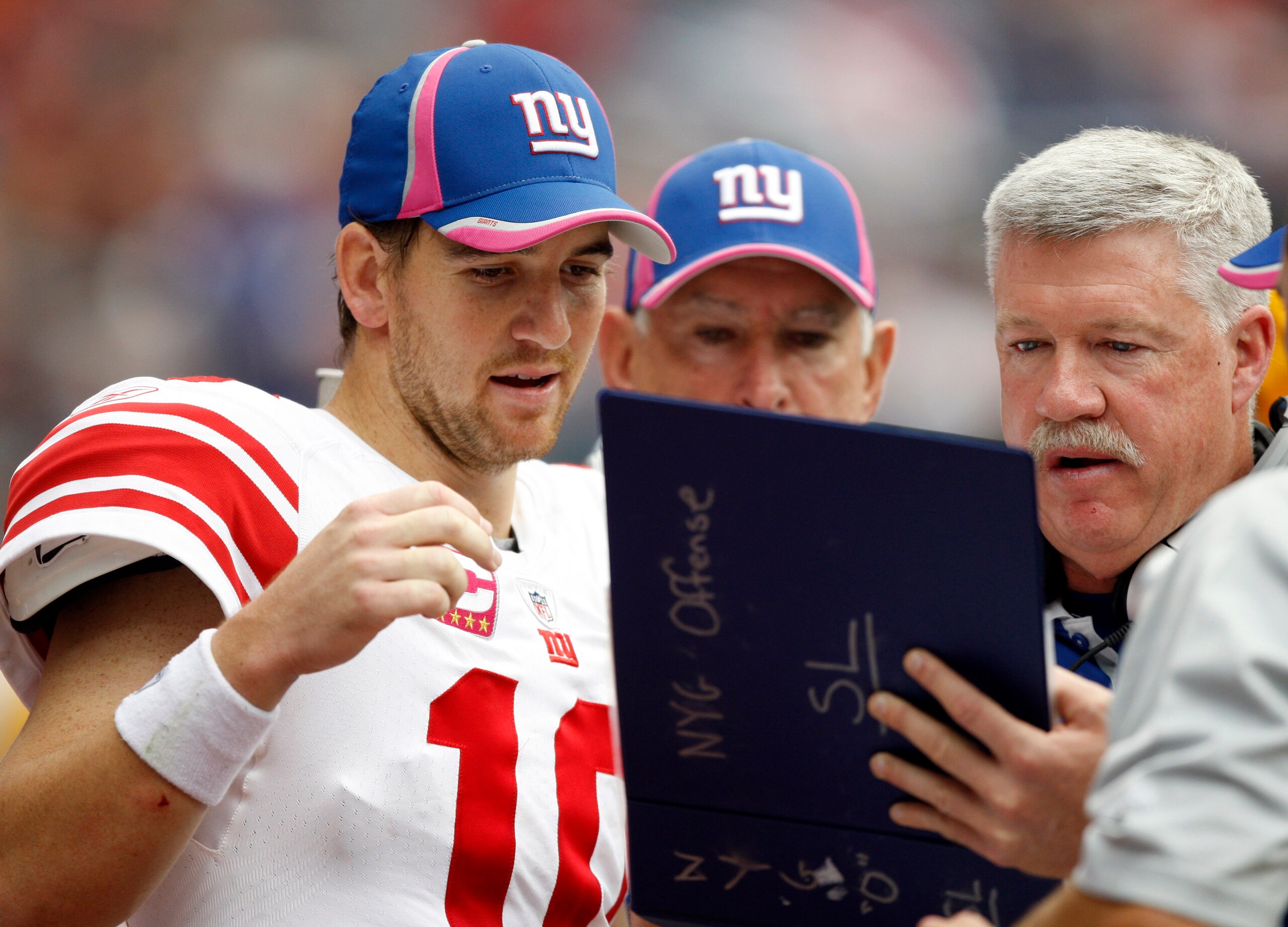 HOUSTON - OCTOBER 10:  Quarterback Eli Manning #10 of the New York Giants looks over plays with offensive coordinator Kevin Gilbride during  a football game against the Houston Texans at Reliant Stadium on October 10, 2010 in Houston, Texas.  (Photo by Bo
