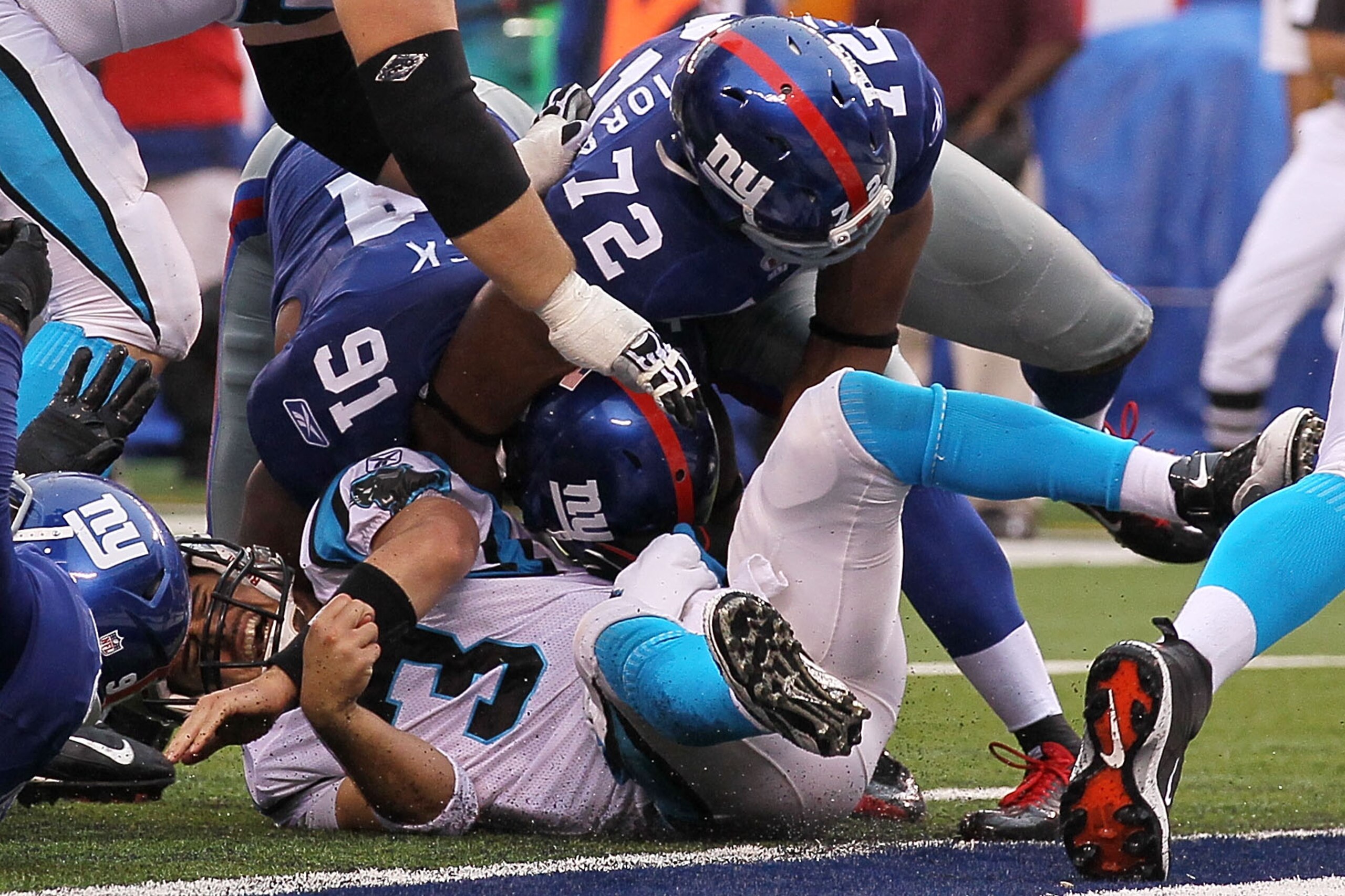 EAST RUTHERFORD, NJ - SEPTEMBER 12:  Matt Moore #3 of the Carolina Panthers is sacked by Justin Tuck #91 and Osi Umenyiora #72 of the New York Giants during the NFL season opener at New Meadowlands Stadium on September 12, 2010 in East Rutherford, New Jer