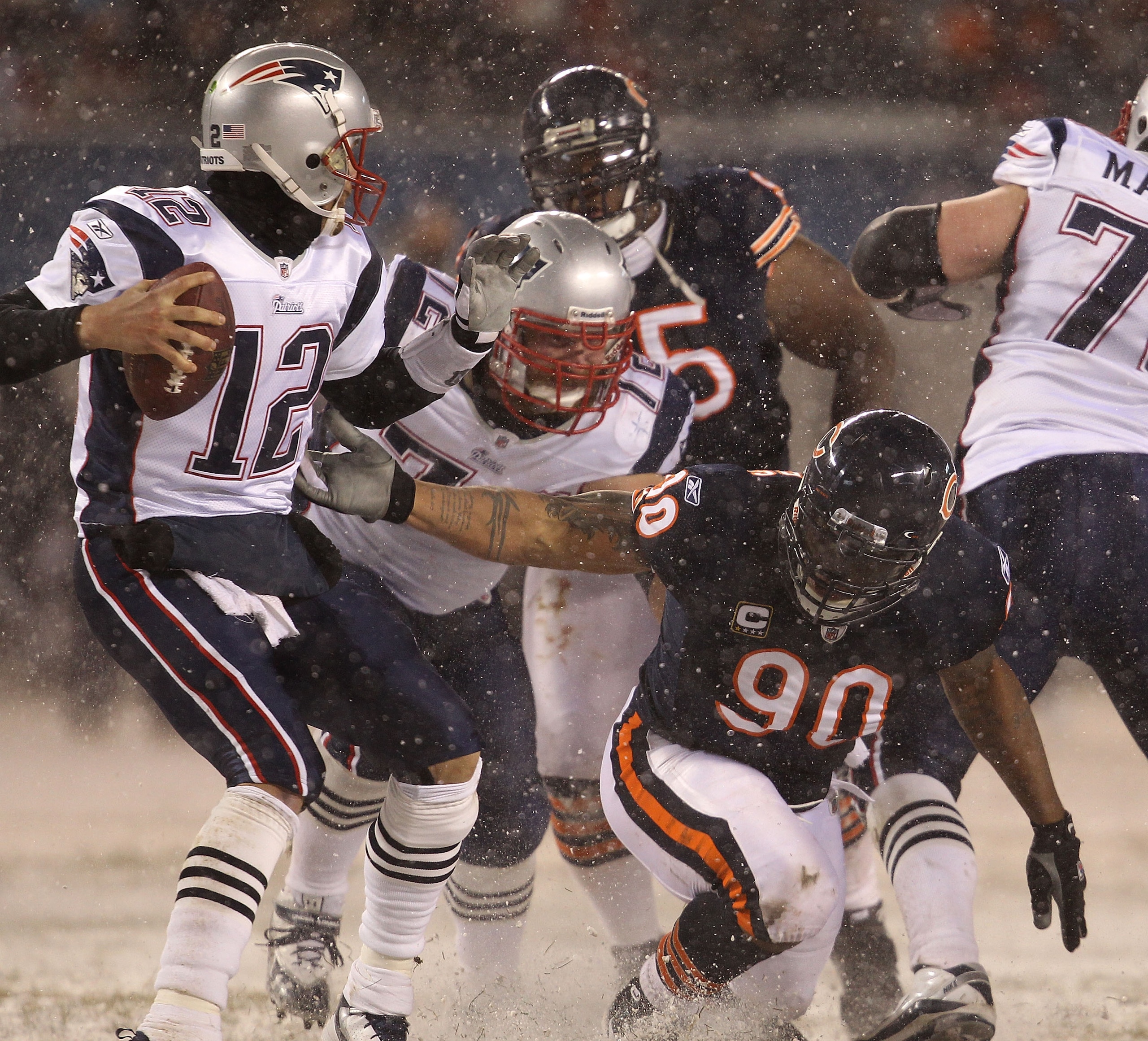 CHICAGO - DECEMBER 12: Julius Peppers #90 of the Chicago Bears slips as he grabs Tom Brady #12 of the New England Patriots at Soldier Field on December 12, 2010 in Chicago, Illinois. The Patriots defeated the Bears 36-7. (Photo by Jonathan Daniel/Getty Im CHICAGO - DECEMBER 12: Julius Peppers #90 of the Chicago Bears slips as he grabs Tom Brady #12 of the New England Patriots at Soldier Field on December 12, 2010 in Chicago, Illinois. The Patriots defeated the Bears 36-7. (Photo by Jonathan Daniel/Getty Im