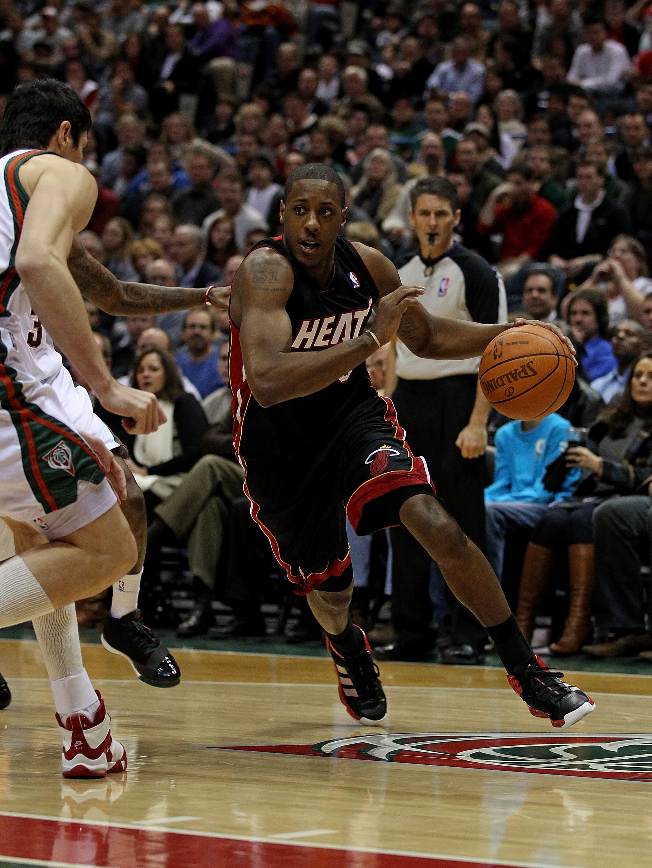 MILWAUKEE, WI - DECEMBER 06: Mario Chalmers #15 of the Miami Heat drives towards Ersan Ilyasova #7 of the Milwaukee Bucks at the Bradley Center on December 6, 2010 in Milwaukee, Wisconsin. The Heat defeated the Bucks 88-78. NOTE TO USER: User expressly ac