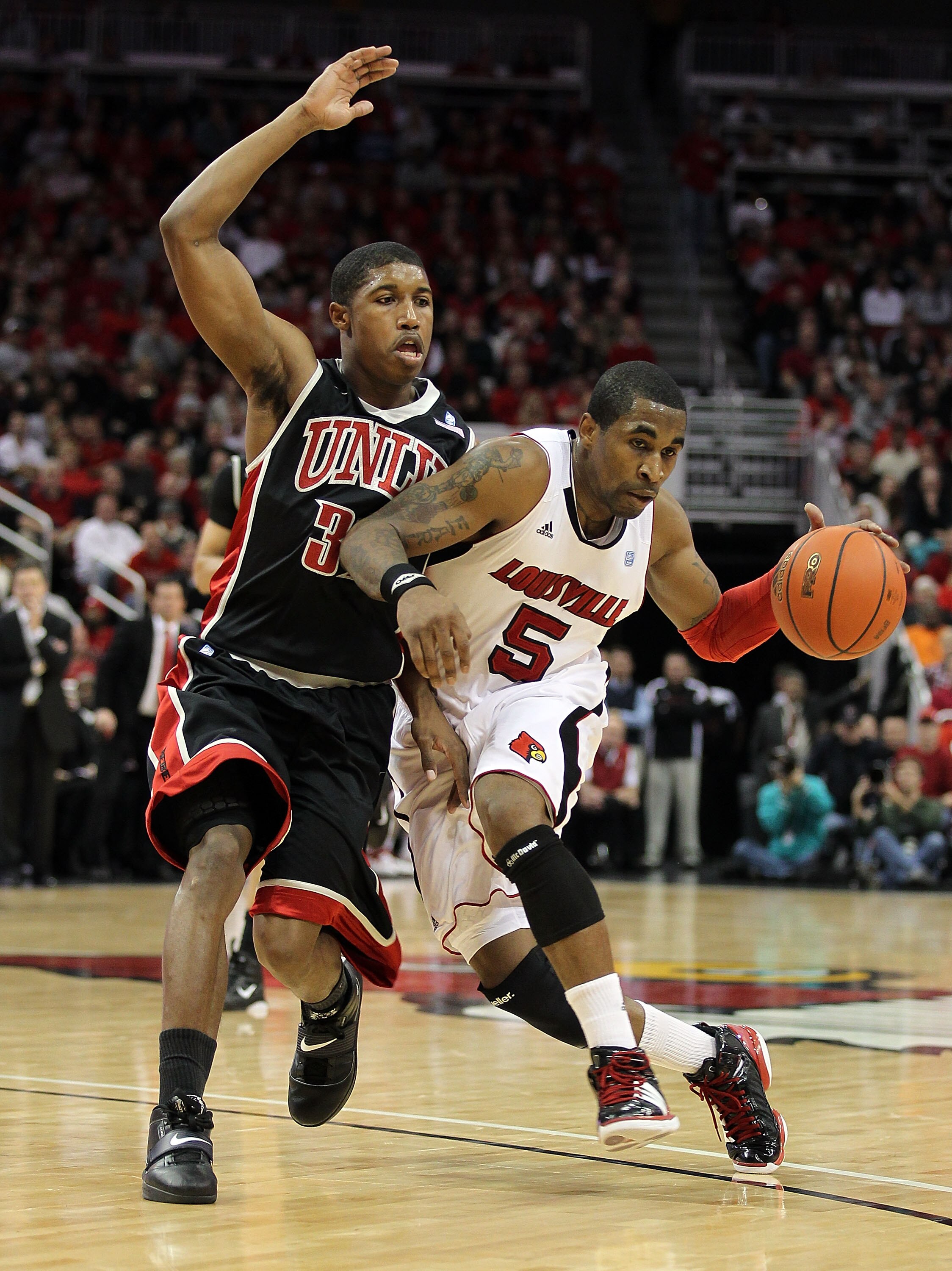 LOUISVILLE, KY - DECEMBER 11:  Chris Smith#5 of the Louisville Cardinals dribbles the ball while defended by Justin Hawkins #31 of the UNLV Runnin' Rebels during the game at KFC YUM! Center on December 11, 2010 in Louisville, Kentucky.  (Photo by Andy Lyo