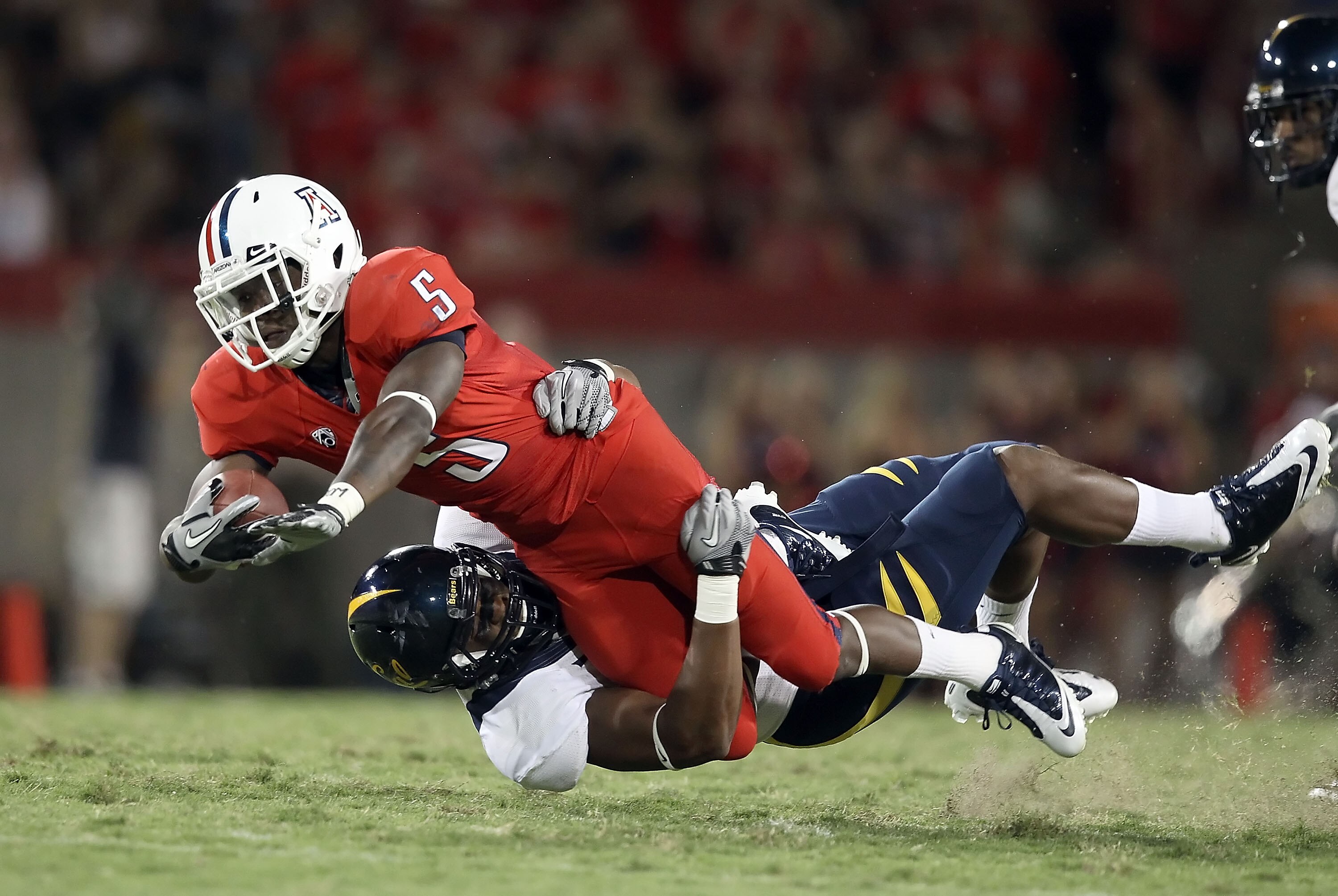 TUCSON, AZ - SEPTEMBER 25:  Runningback Nic Grigsby #5 of the Arizona Wildcats is tackled by Cameron Jordan #97 of the California Golden Bears after a 10 yard reception during the second quarter of the college football game at Arizona Stadium on September