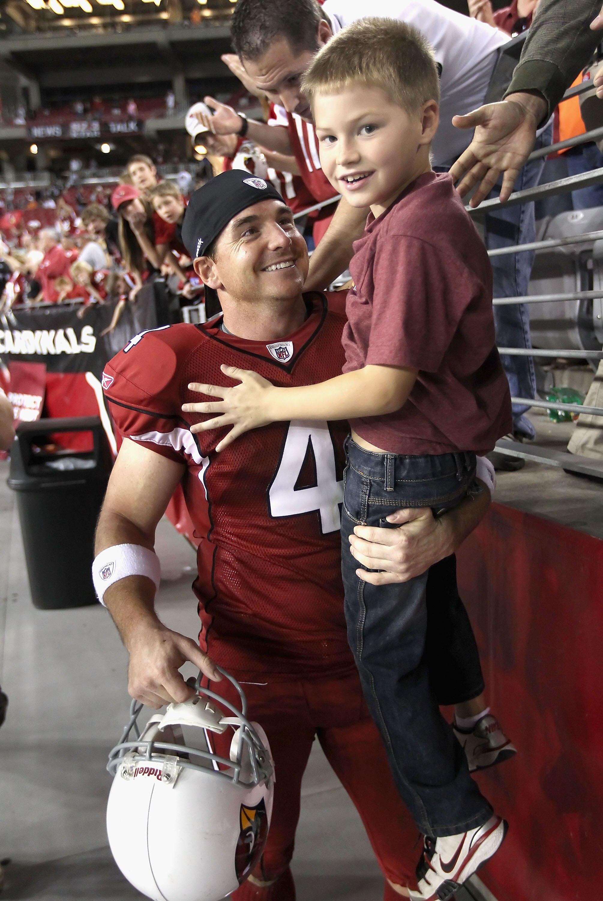 GLENDALE, AZ - DECEMBER 12:  Kicker Jay Feely #4 of the Arizona Cardinals lifts his son Jace out of the crowd following the NFL game against the Denver Broncos at the University of Phoenix Stadium on December 12, 2010 in Glendale, Arizona.  The Cardinals