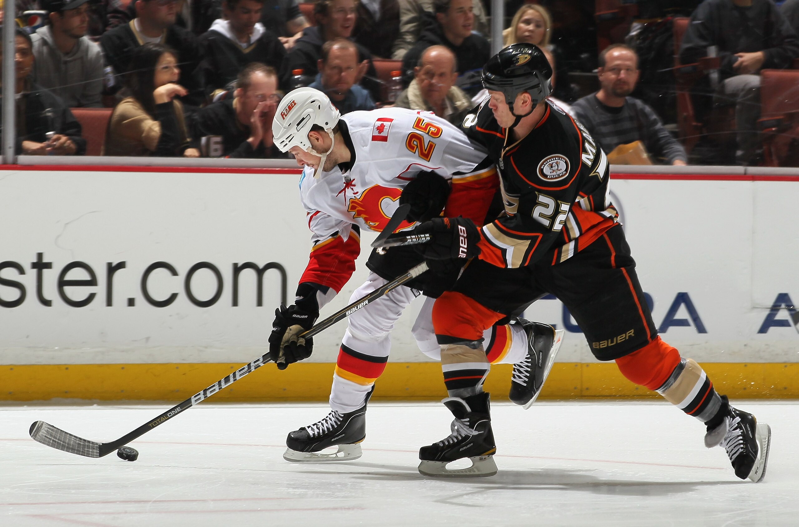 ANAHEIM, CA - DECEMBER 10:  Todd Marchant #22 of the Anaheim Ducks and David Moss #25 of the Calgary Flames battle for the puck in the third period at the Honda Center on December 10, 2010 in Anaheim, California. The Ducks defeated the Flames 3-2 in a sho