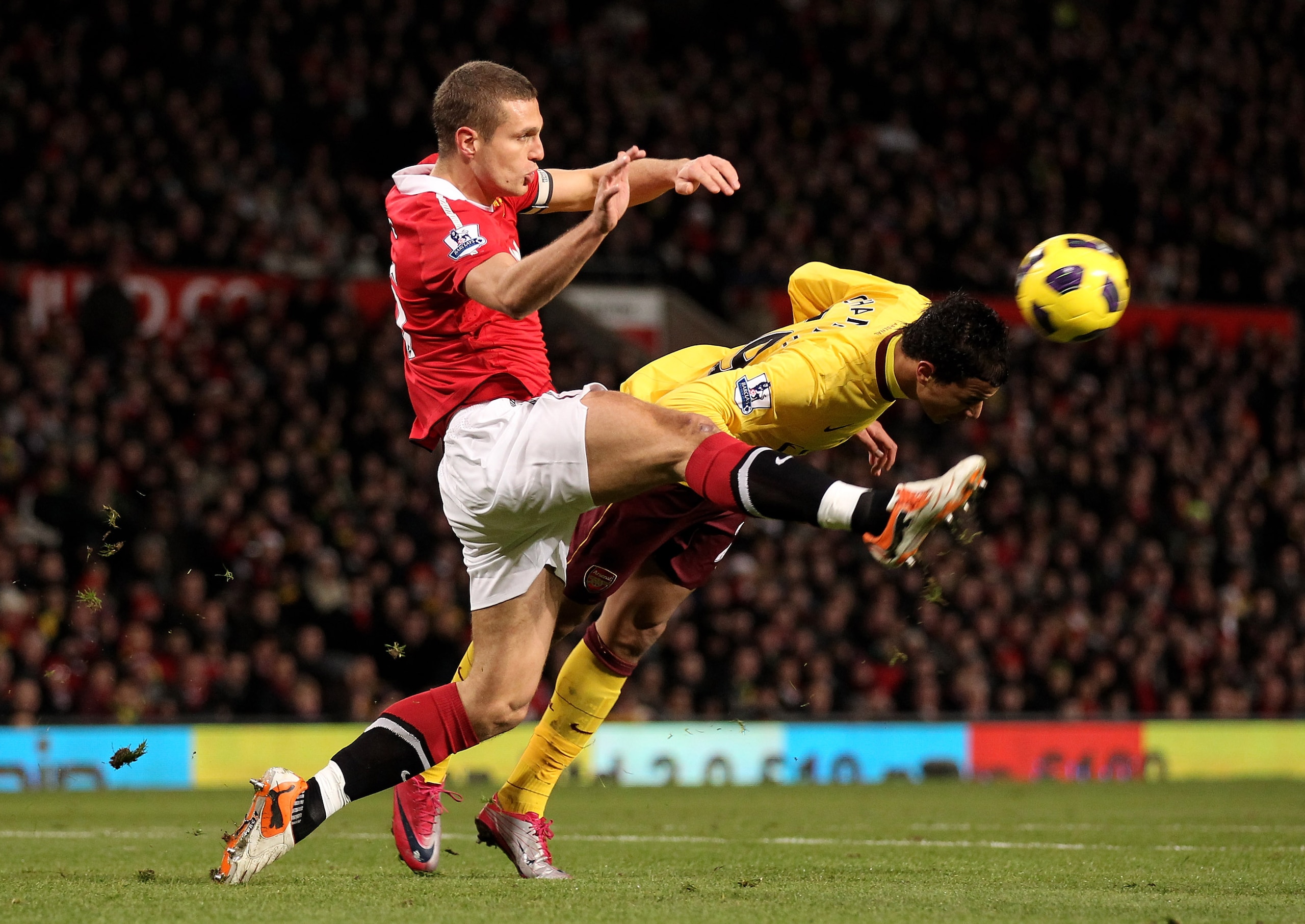 MANCHESTER, UNITED KINGDOM - DECEMBER 13: Nemanja Vidic of Manchester United competes for the ball with Marouane Chamakh of Arsenal during the Barclays Premier League match between Manchester United and Arsenal at Old Trafford on December 13, 2010 in M MANCHESTER, UNITED KINGDOM - DECEMBER 13: Nemanja Vidic of Manchester United competes for the ball with Marouane Chamakh of Arsenal during the Barclays Premier League match between Manchester United and Arsenal at Old Trafford on December 13, 2010 in M