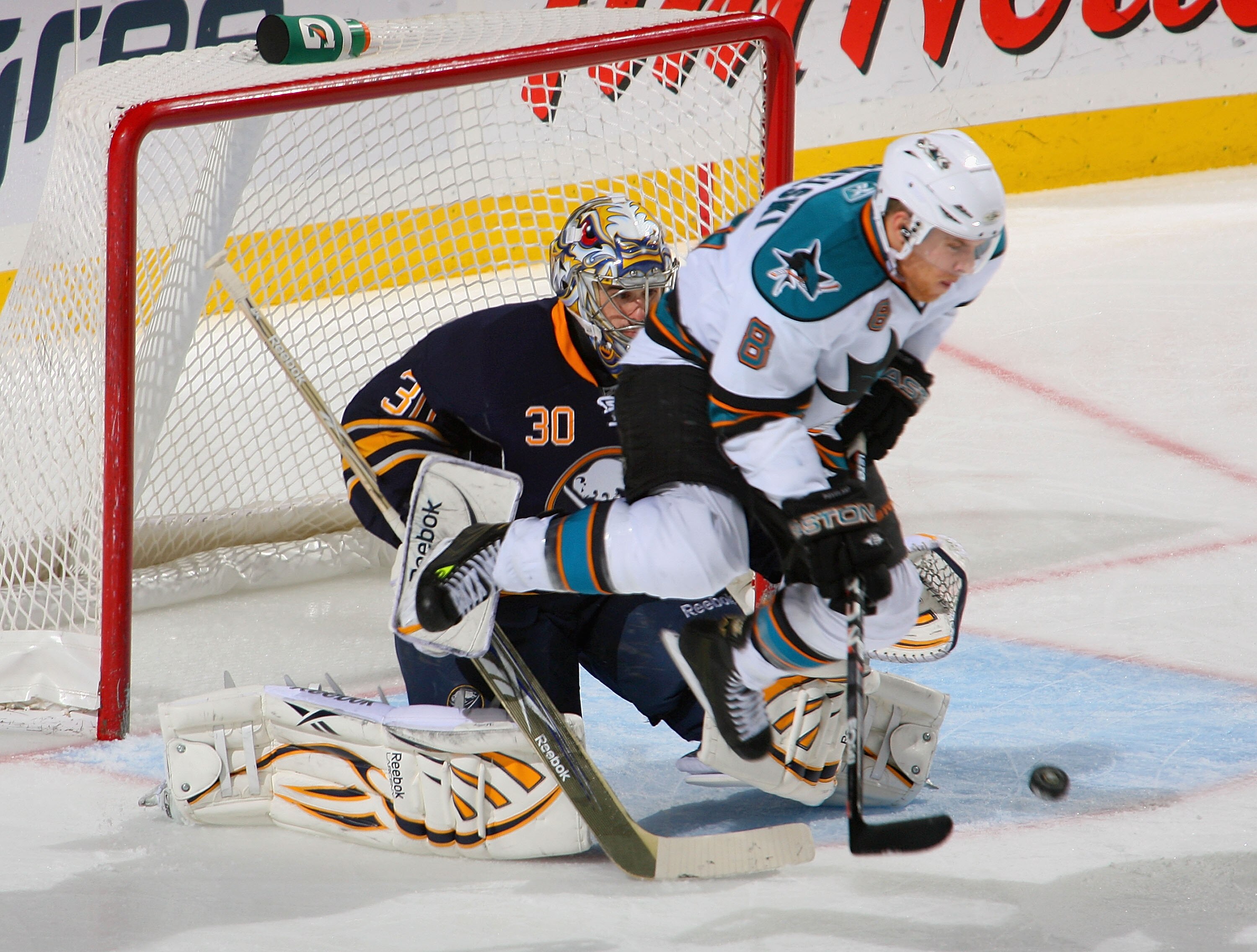 BUFFALO, NY - DECEMBER 09: Ryan Miller #30 of the Buffalo Sabres is screened by a jumping Joe Pavelski #8 of the San Jose Sharks on a goal by Douglas Murray #3 of the Sharks (not shown) at HSBC Arena on December 9, 2010 in Buffalo, New York. Buffalo won 6