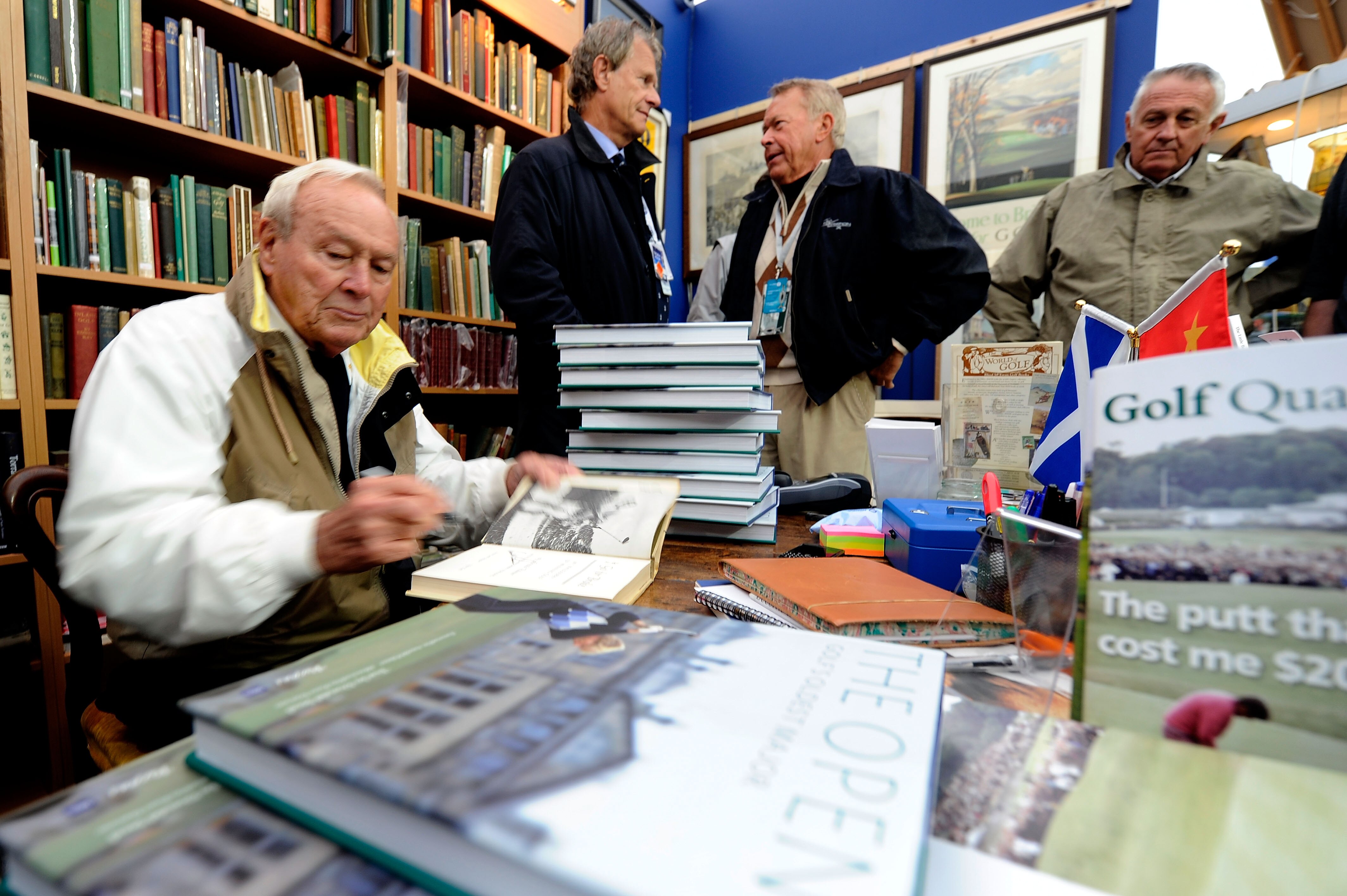 ST ANDREWS, SCOTLAND - JULY 14:  Arnold Palmer autographs books for fans at the merchandise pavilion during practice for the 139th Open Championship on the Old Course, St Andrews on July 14, 2010 in St Andrews, Scotland.  (Photo by Stuart Franklin/Getty I