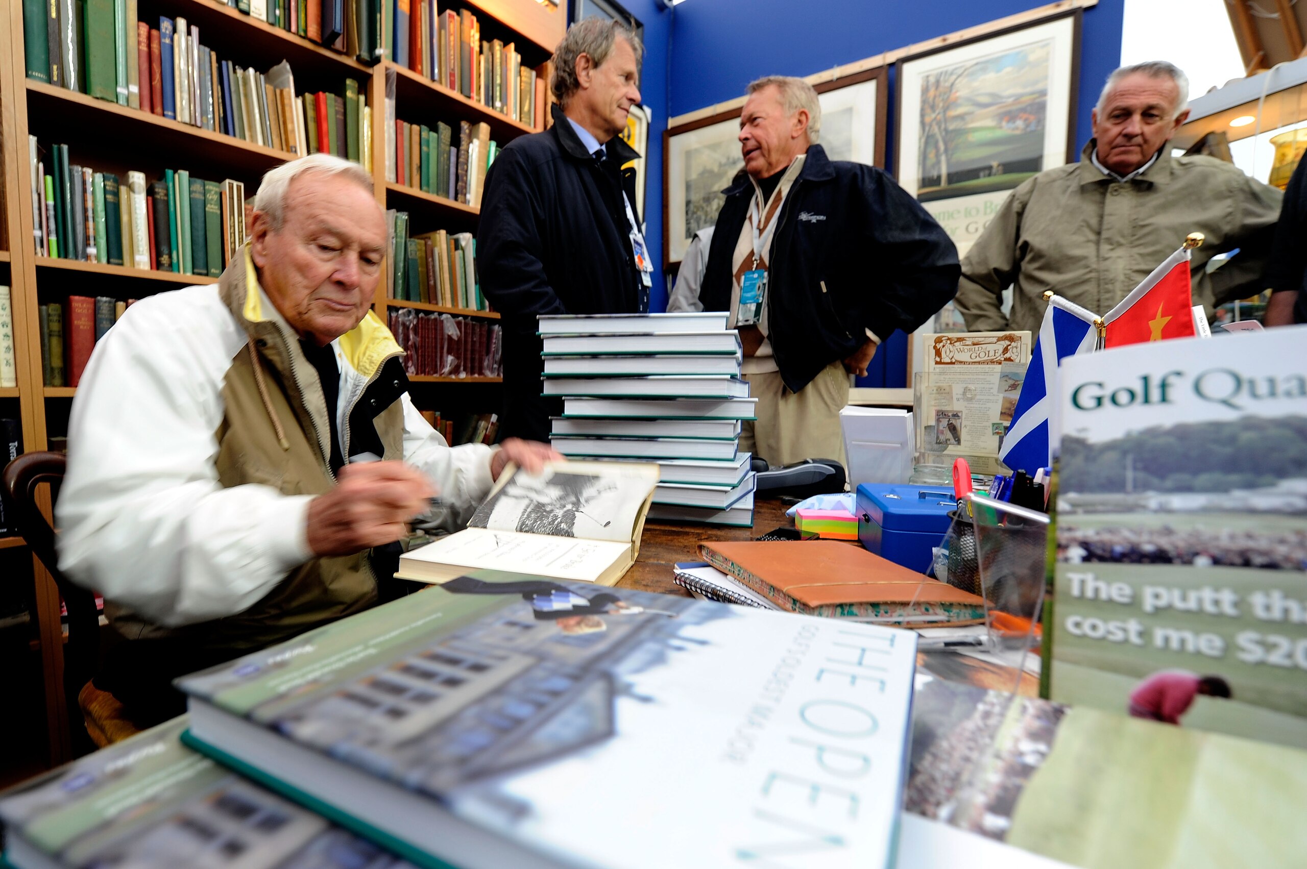 ST ANDREWS, SCOTLAND - JULY 14:  Arnold Palmer autographs books for fans at the merchandise pavilion during practice for the 139th Open Championship on the Old Course, St Andrews on July 14, 2010 in St Andrews, Scotland.  (Photo by Stuart Franklin/Getty I