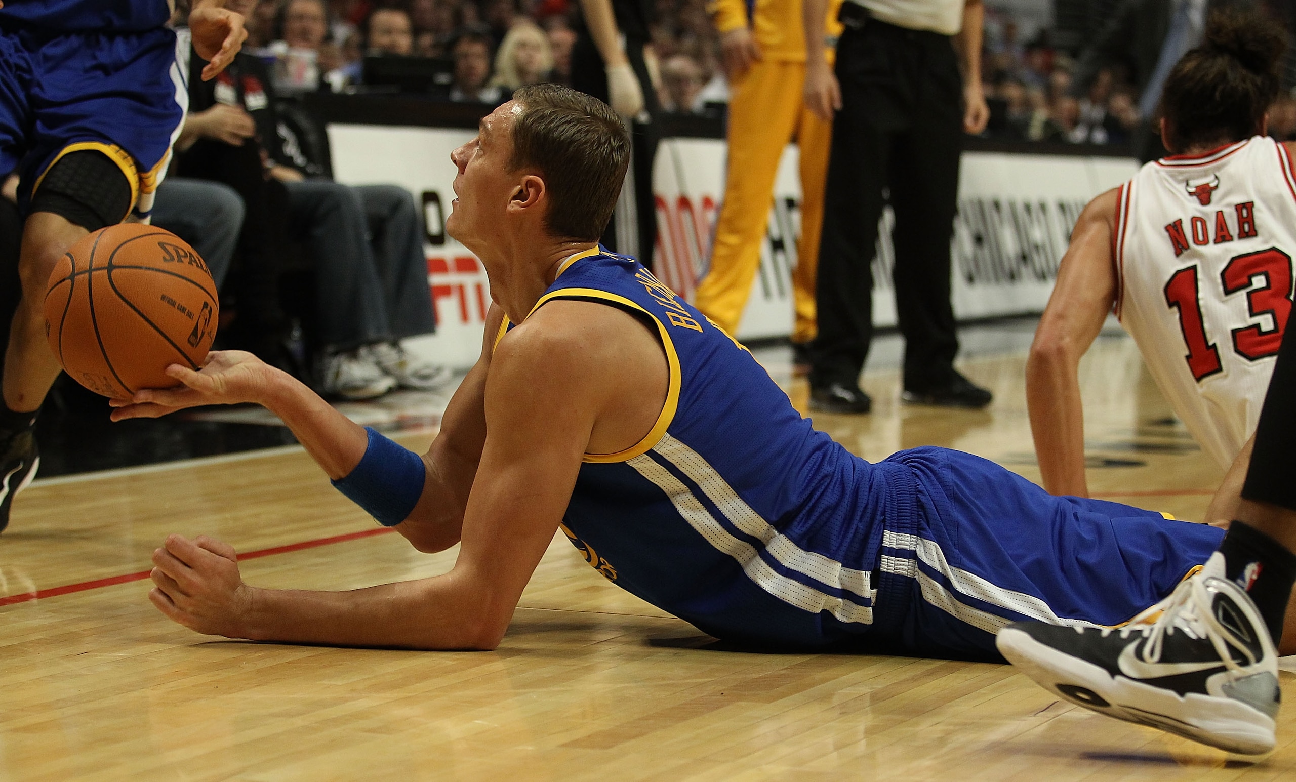 CHICAGO - NOVEMBER 11: Andris Biedrins #15 of the Golden State Warriors hands the ball off to a teammate after a scramble on the floor against the Chicago Bulls at the United Center on November 11, 2010 in Chicago, Illinois. NOTE TO USER: User expressly a