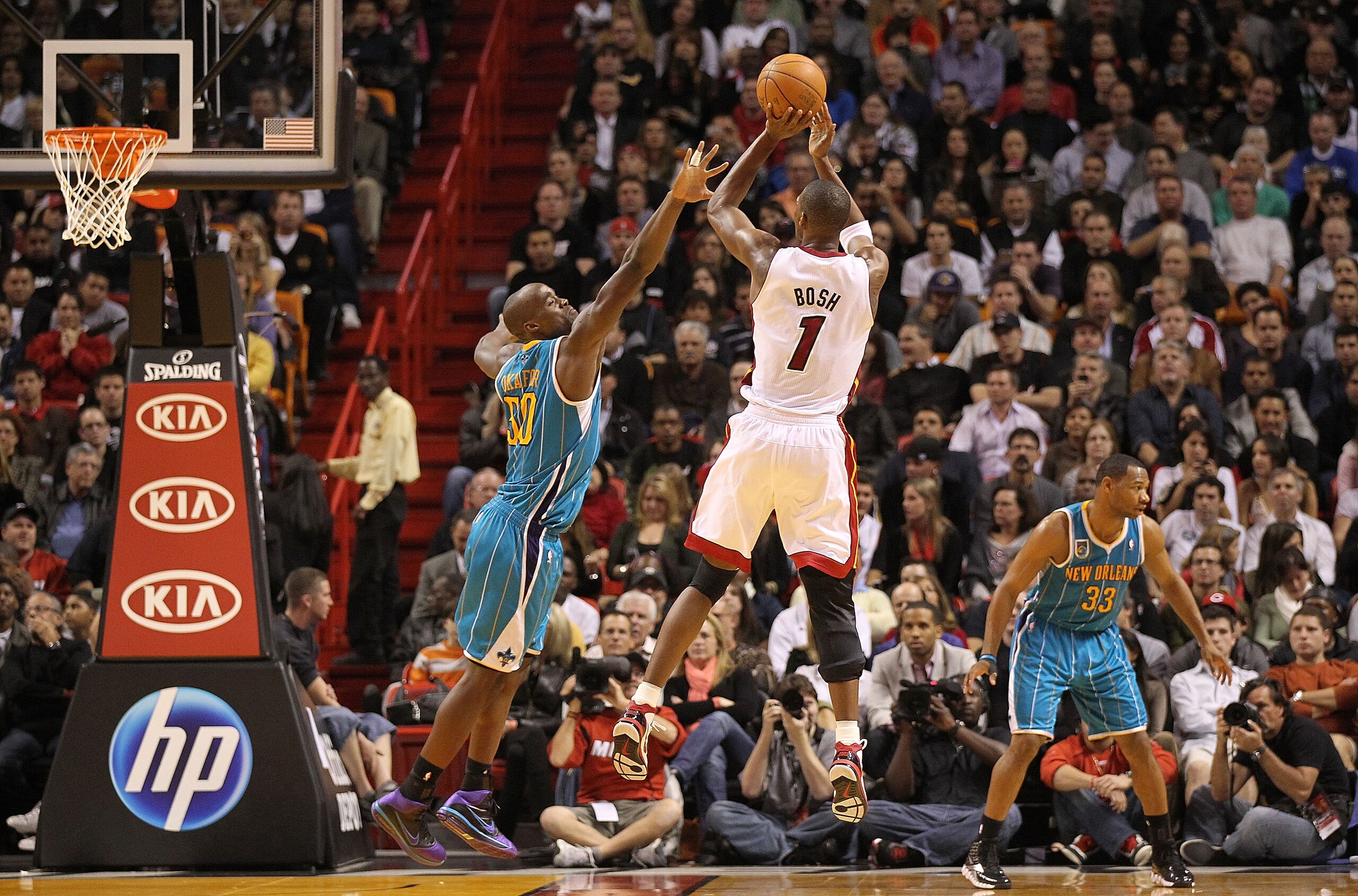 MIAMI, FL - DECEMBER 13:  Chris Bosh #1 of the Miami Heat shoots over Emeka Okafor #50 of the New Orleans Hornets during a game at American Airlines Arena on December 13, 2010 in Miami, Florida. NOTE TO USER: User expressly acknowledges and agrees that, b