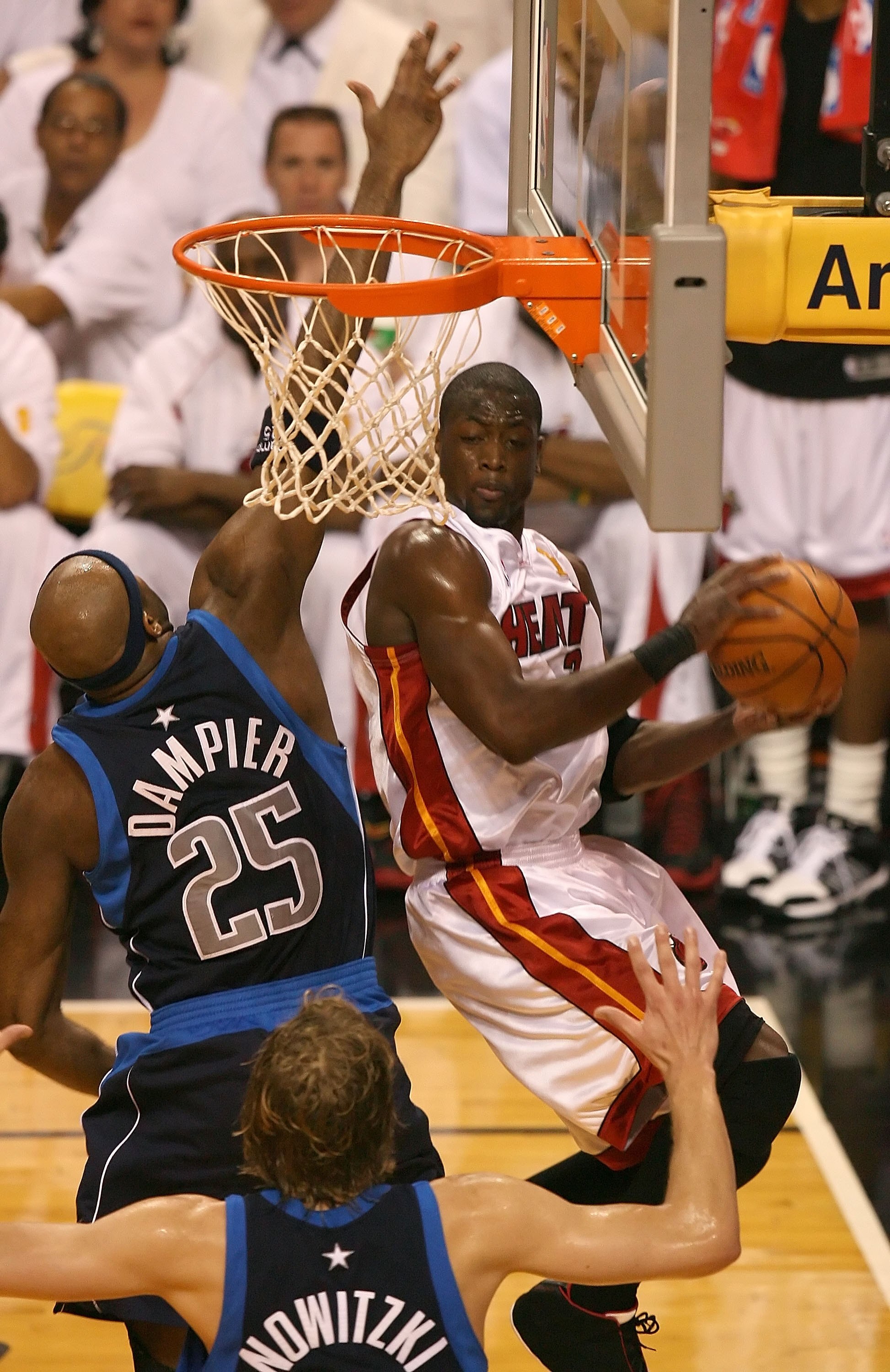 MIAMI - JUNE 18:  Dwyane Wade #3 of the Miami Heat looks the pass the ball against Erick Dampier #25 and Dirk Nowitzki #41 of the Dallas Mavericks in game five of the 2006 NBA Finals on June 18, 2006 at American Airlines Arena in Miami, Florida.  NOTE TO