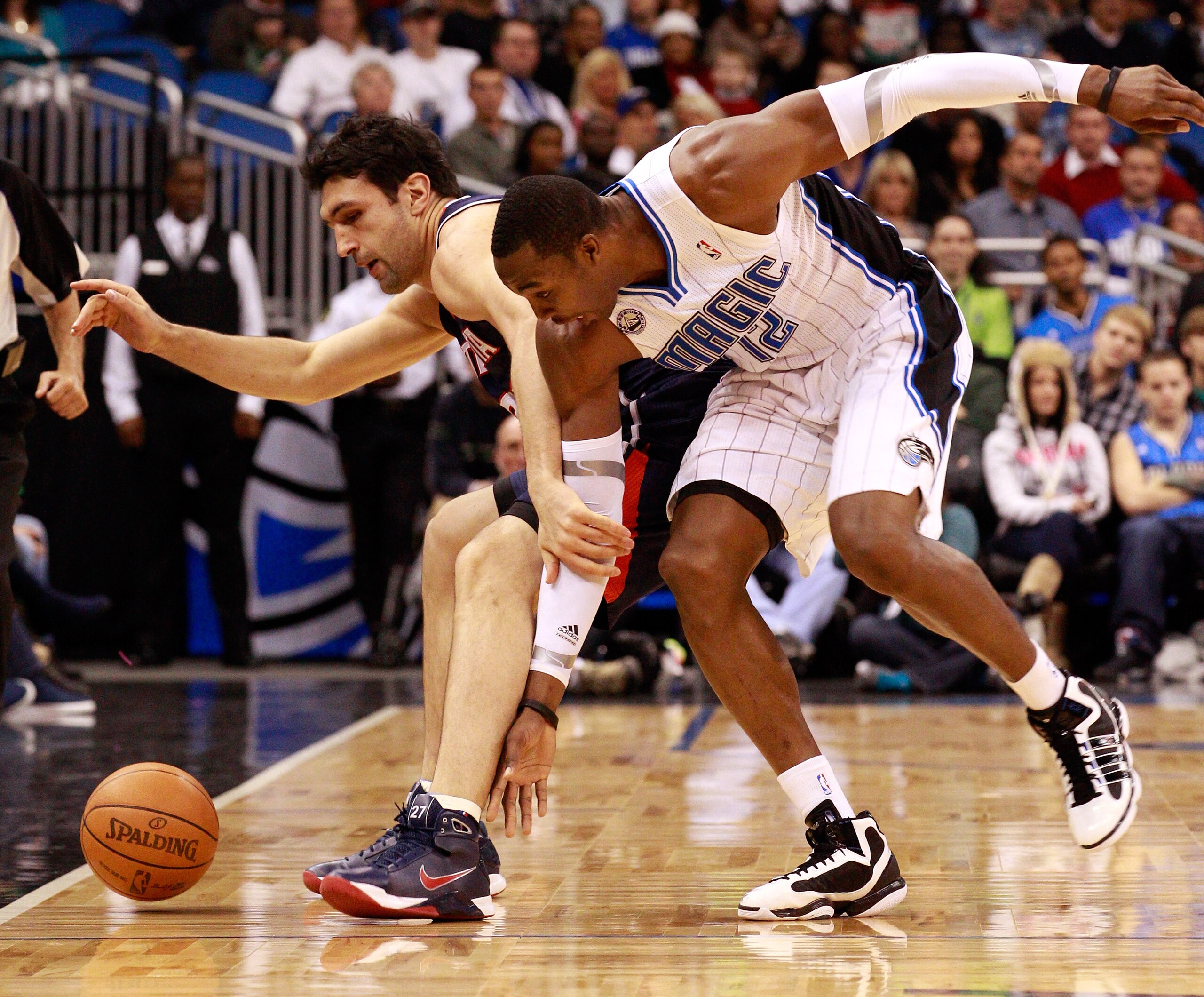 ORLANDO, FL - DECEMBER 06: Dwight Howard #12 of the Orlando Magic and Zaza Pachulia #27 of the Atlanta Hawks battle for a loose ball during the game at Amway Arena on December 6, 2010 in Orlando, Florida. NOTE TO USER: User expressly acknowledges and agr ORLANDO, FL - DECEMBER 06: Dwight Howard #12 of the Orlando Magic and Zaza Pachulia #27 of the Atlanta Hawks battle for a loose ball during the game at Amway Arena on December 6, 2010 in Orlando, Florida. NOTE TO USER: User expressly acknowledges and agr