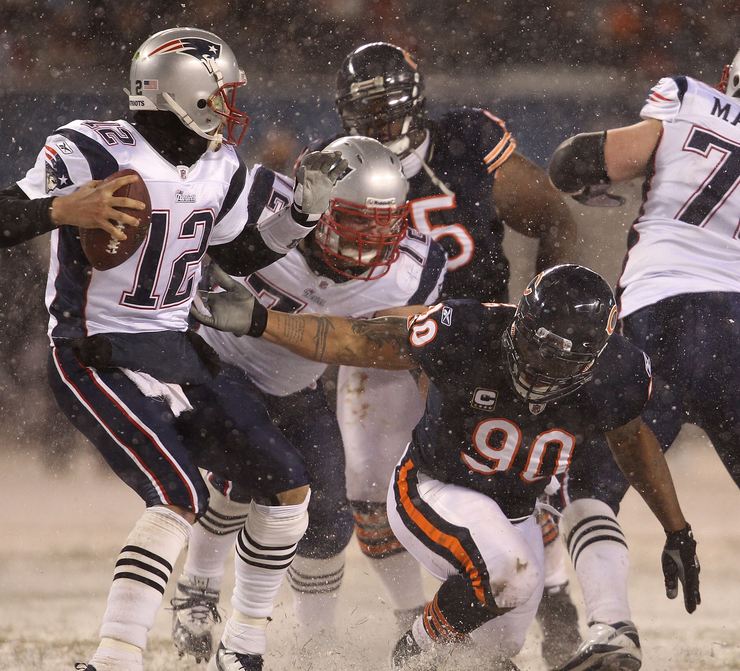 CHICAGO - DECEMBER 12: Julius Peppers #90 of the Chicago Bears slips as he grabs Tom Brady #12 of the New England Patriots at Soldier Field on December 12, 2010 in Chicago, Illinois. The Patriots defeated the Bears 36-7. (Photo by Jonathan Daniel/Getty Im