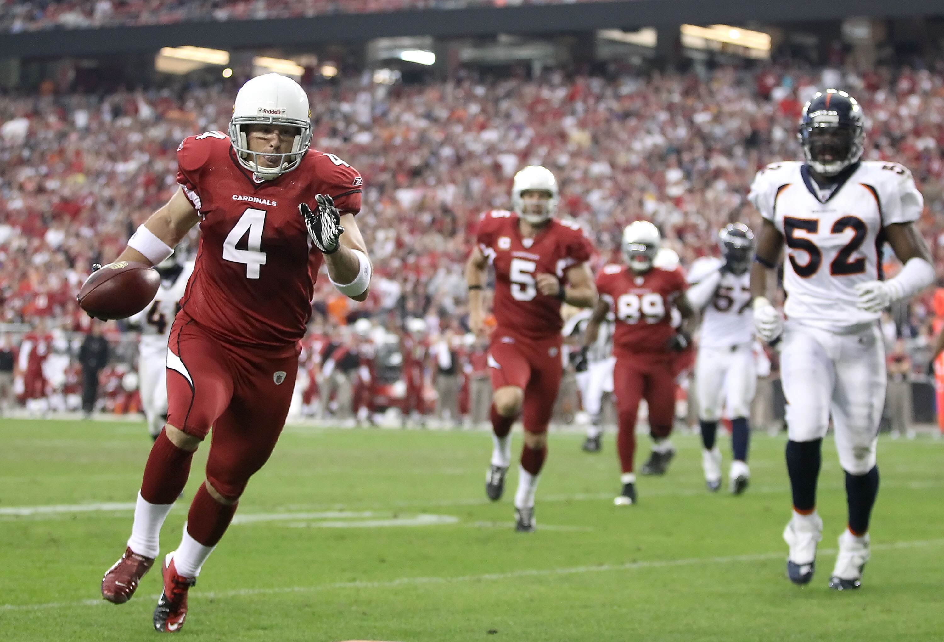 GLENDALE, AZ - DECEMBER 12:  Place kicker Jay Feely #4 of the Arizona Cardinals runs with the football for a 5 yard rushing touchdown past Jason Hunter #52 of the Denver Broncos during the second quarter of the NFL game at the University of Phoenix Stadiu