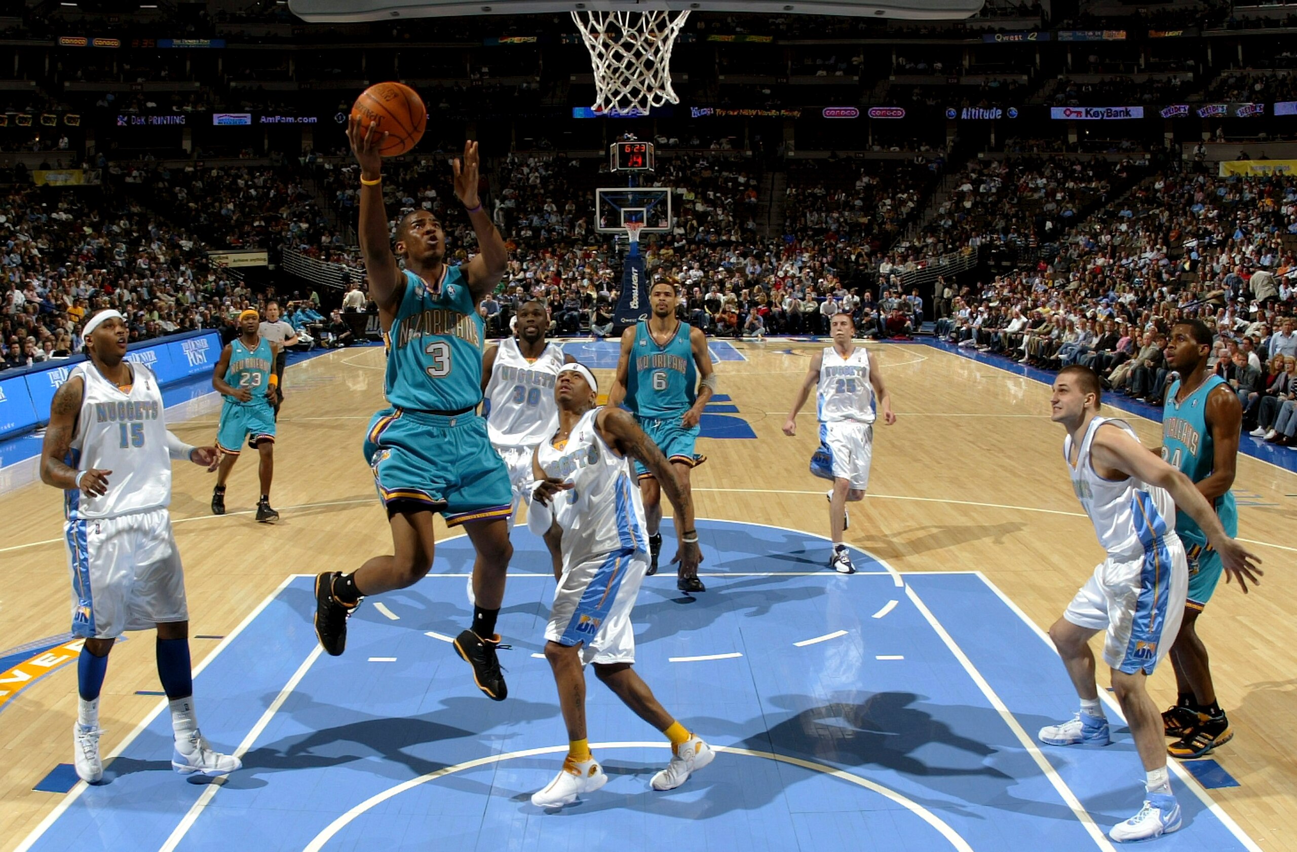 DENVER - FEBRUARY 07:  Chris Paul #3 of the New Orleans/Oklahoma City Hornets lays up a shot between Carmelo Anthony #15 and Allen Iverson #3 of the Denver Nuggets as the Hornets defeated the Nuggets 114-112 in overtime during NBA action on February 7, 20