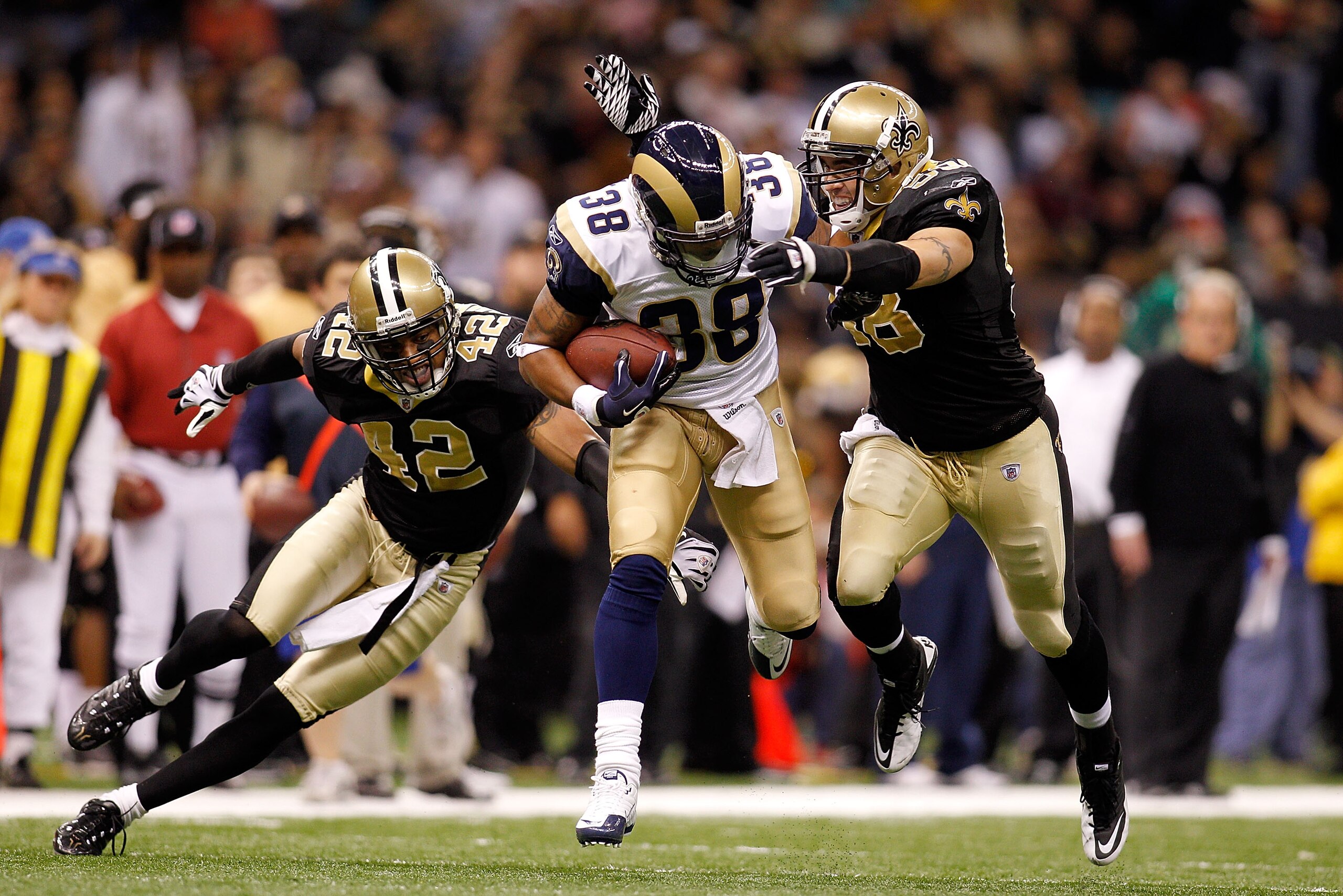 NEW ORLEANS, LA - DECEMBER 12: Keith Toston #38 of the St. Louis Rams is tackled by Darren Sharper #42 and Scott Shanle #58 of the New Orleans Saints at the Louisiana Superdome on December 12, 2010 in New Orleans, Louisiana. The Saints defeated the Rams 3