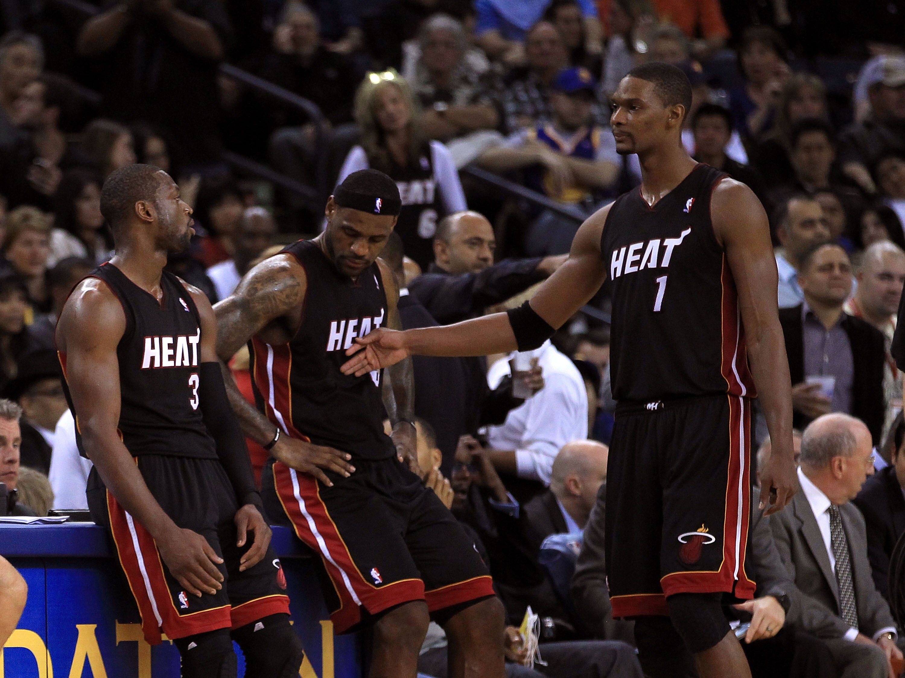 OAKLAND, CA - DECEMBER 10:  Dwayne Wade #3, Lebron James and Chris Bosh #1   of the Miami Heat wait on the side of the court during a time out of their game against the Golden State Warriors at Oracle Arena on December 10, 2010 in Oakland, California. NOT