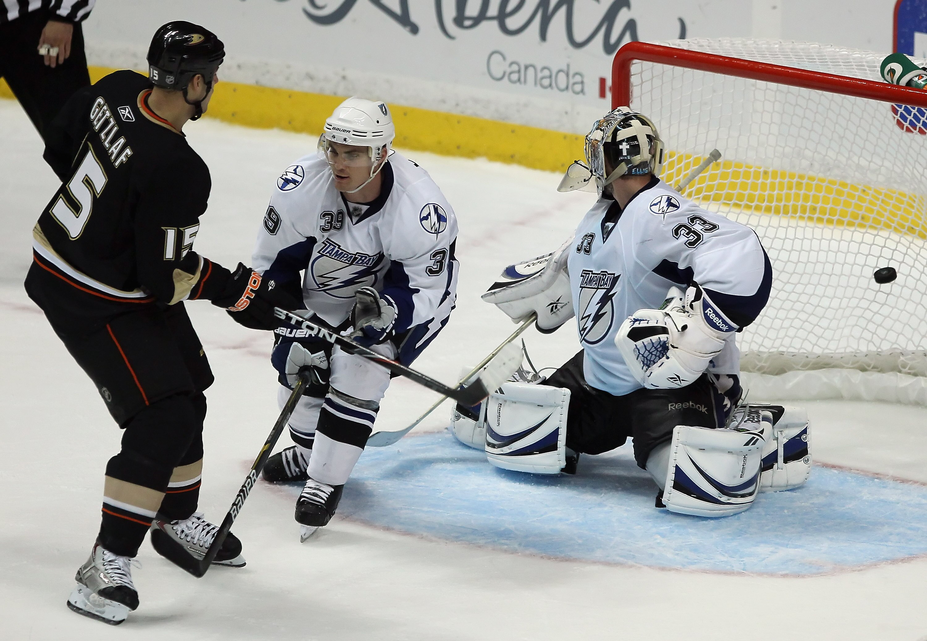 ANAHEIM, CA - NOVEMBER 03:  (L-R) Ryan Getzlaf #15 of the Anaheim Ducks scores the game winning goal in overtime as Mike Lundin #39 and goaltender Dan Ellis #33 of the Tampa Bay Lightning defend at the Honda Center on November 3, 2010 in Anaheim, Californ