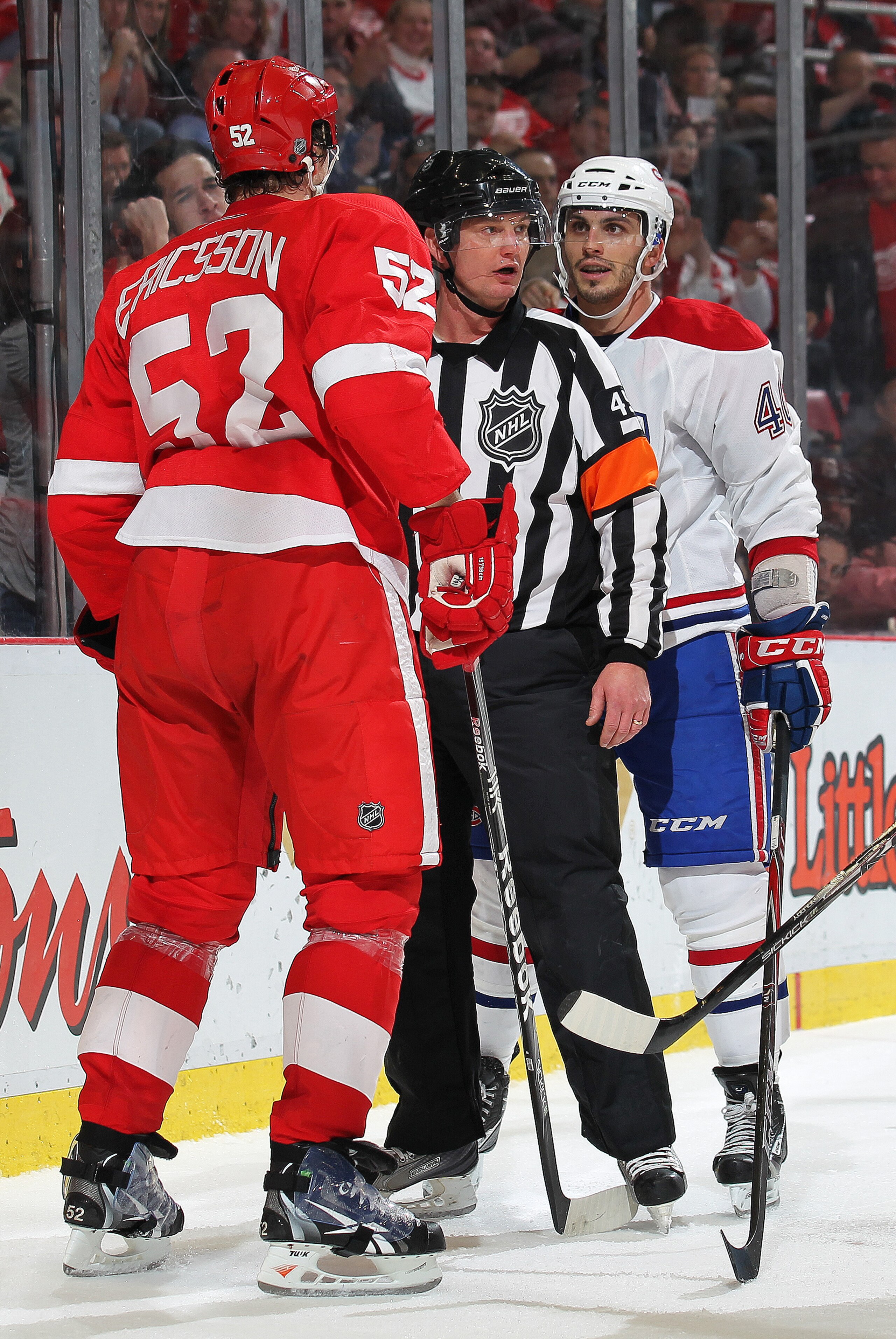 DETROIT,MI - DECEMBER 10:  Maxim Lapierre #40 of the Montreal Canadiens and Jonathan Ericsson #52 of the Detroit Red Wings are separated by a referee during the game at the Joe Louis Arena on December 10, 2010  in Detroit, Michigan. The Wings defeated the