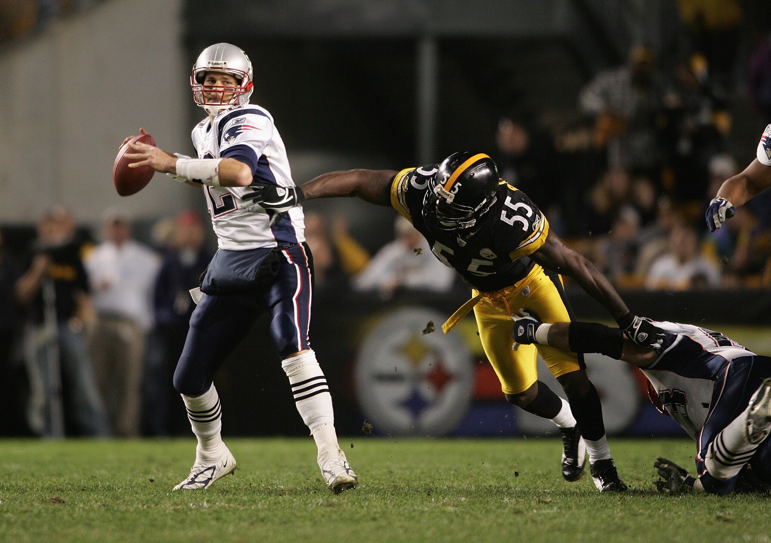 PITTSBURGH - OCTOBER 31:  Quarterback Tom Brady #12 of the New England Patriots attempts to pass the ball before being sacked by outside linebacker Joey Porter #55 of the Pittsburgh Steelers during the game at Heinz Field on October 31, 2004 in Pittsburgh
