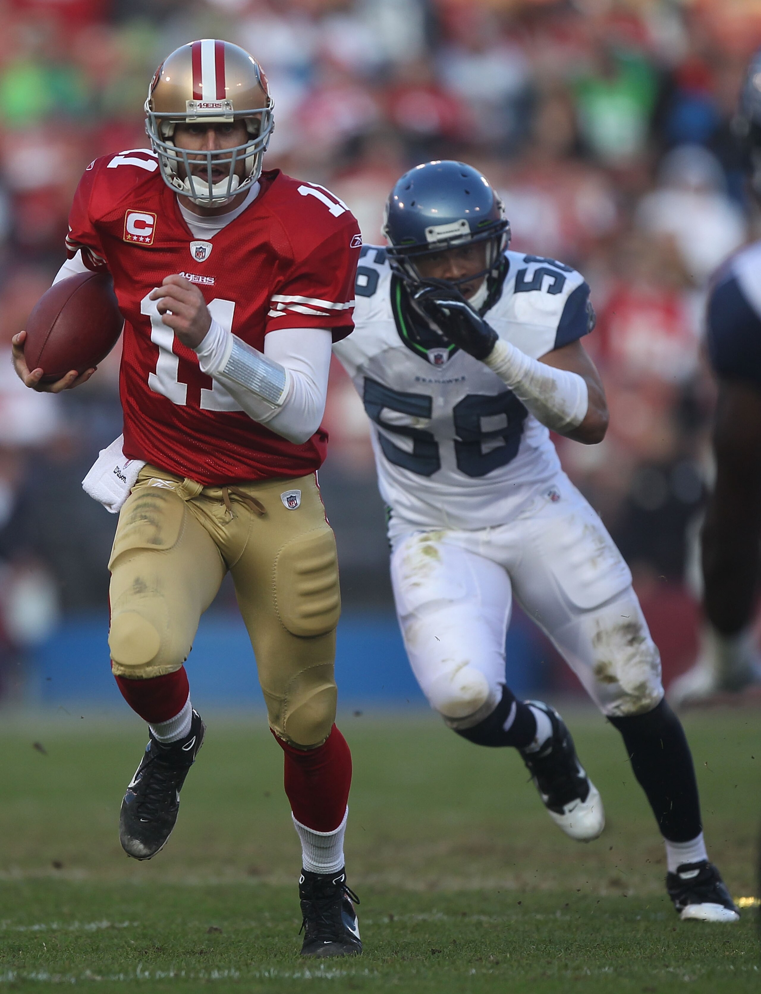 SAN FRANCISCO - DECEMBER 12:    Alex Smith #11 of the San Francisco 49ers runs with the ball against Dexter Davis #58 of the Seattle Seahawks during an NFL game at Candlestick Park on December 12, 2010 in San Francisco, California.  (Photo by Jed Jacobsoh