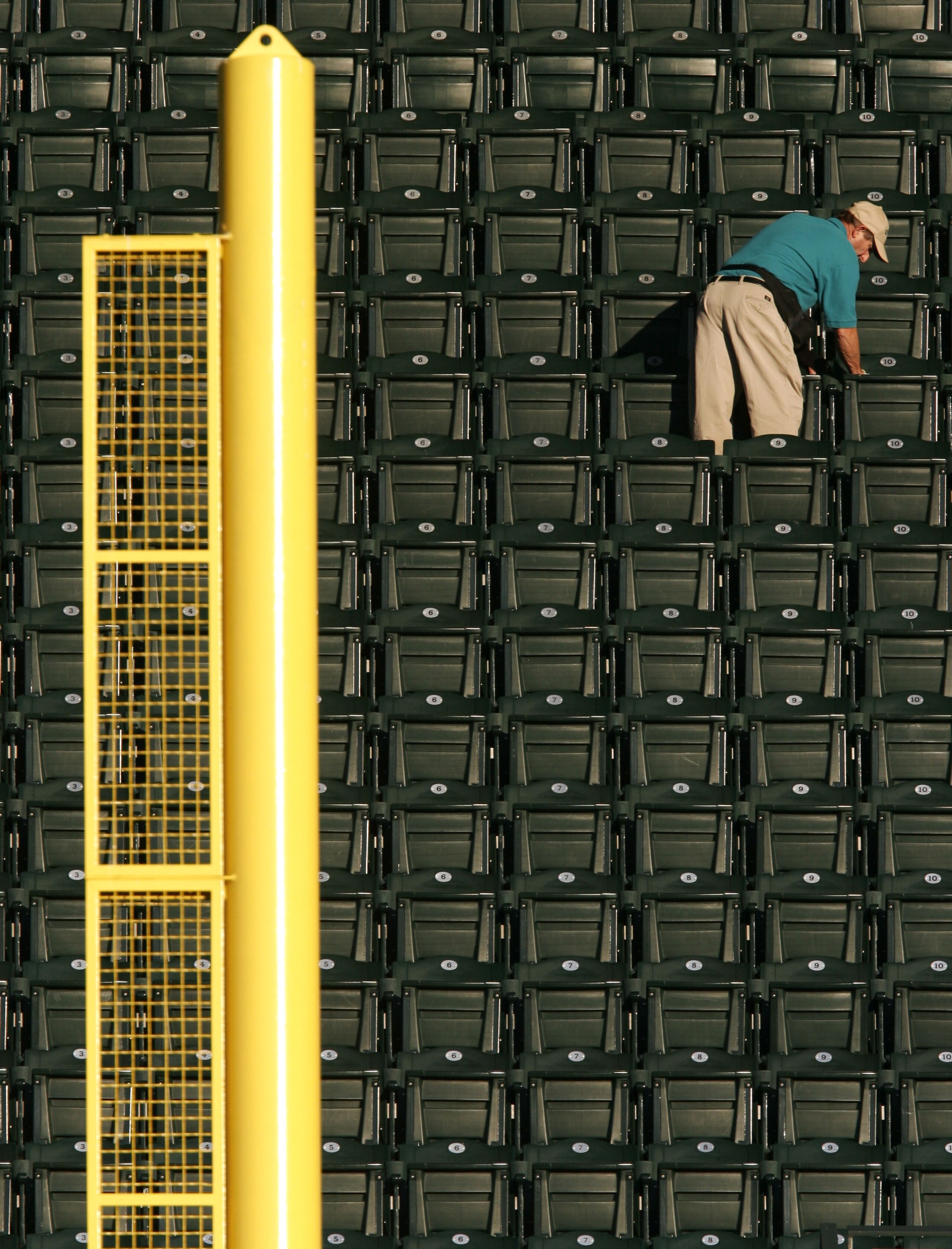 SEATTLE - SEPTEMBER 27:  A worker cleans seats in the upper deck behind the right field foul pole prior to the game between the Texas Rangers and the Seattle Mariners on September 27, 2005 at Safeco Field in Seattle, Washington.  (Photo by Otto Greule Jr/