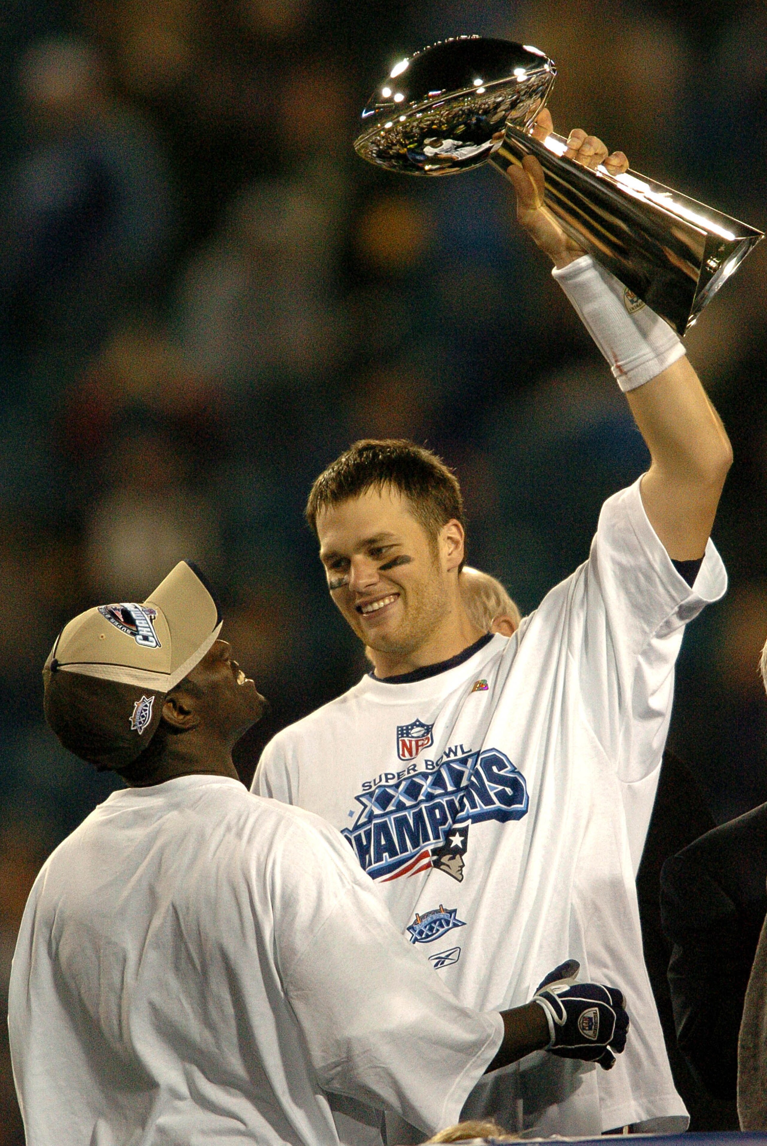 Tom Brady holds the Vince Lombardi Trophy as he stands on the podium with Deion Branch after The New England Patriots defeated The Philadelphia Eagles in Super Bowl XXXIX at Alltel Staduim in Jacksonville, Florida. (Photo by Steve Grayson/Getty Images)