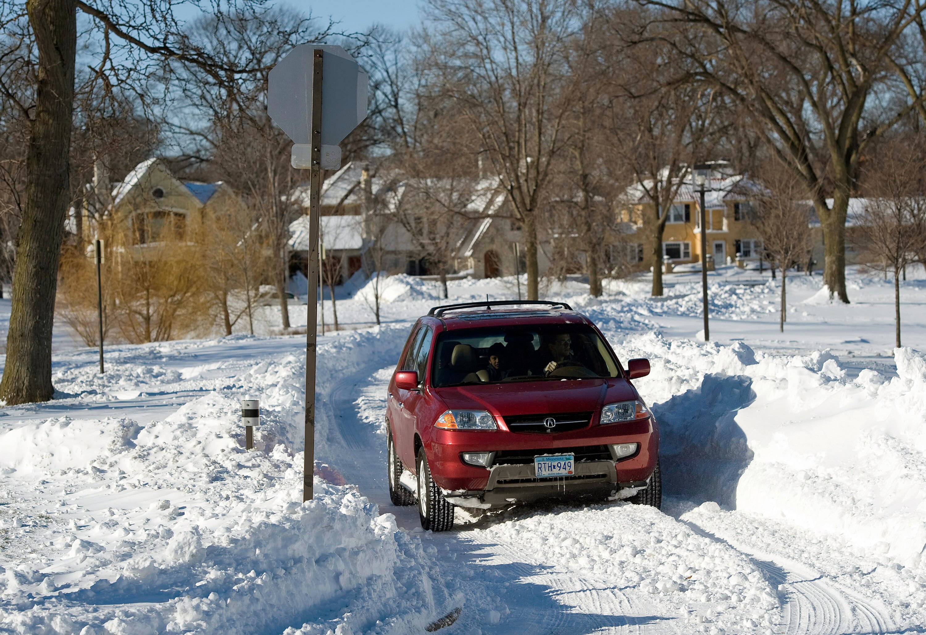 MINNEAPOLIS, MN - DECEMBER 12:   A car navigates a one track snow covered road after a snow storm December 12, 2010 in Minneapolis, Minnesota. A blizzard dumped more than 20 inches of snow in parts of the Midwest forcing the NFL football game between the
