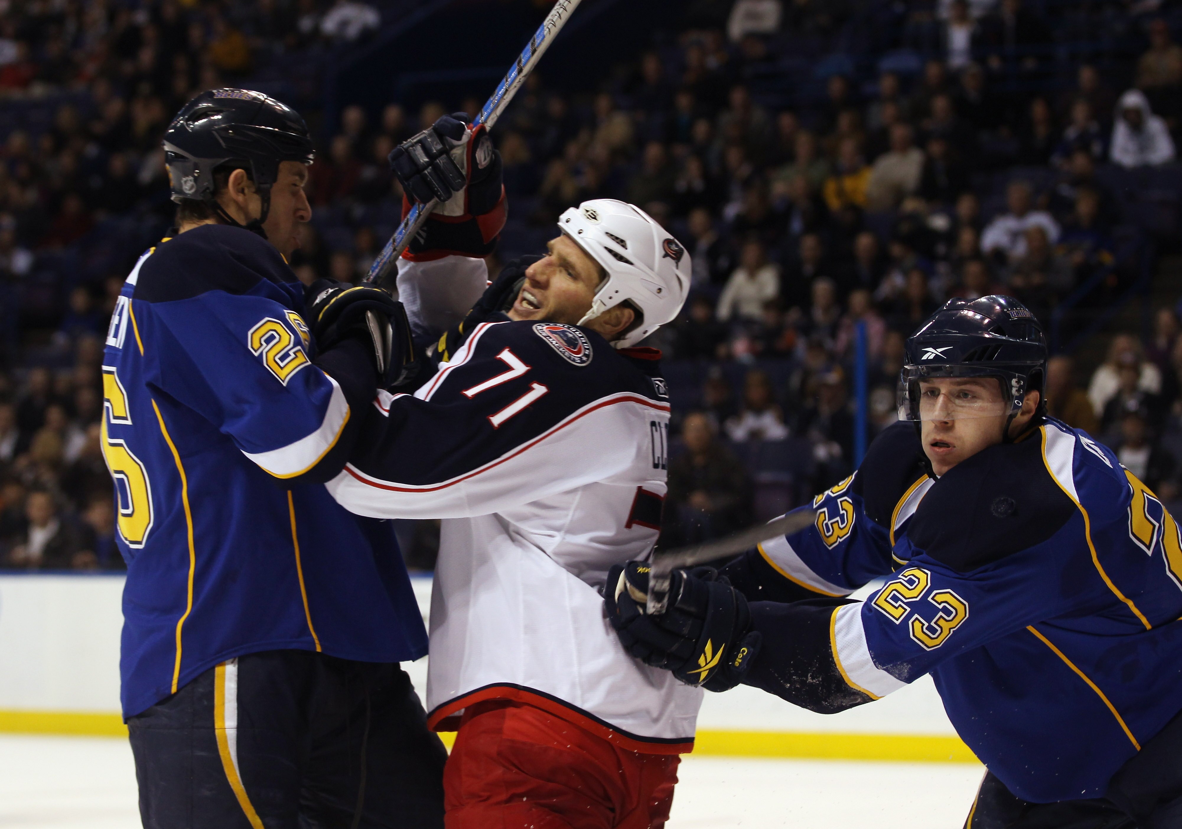 ST LOUIS, MO - DECEMBER 09: BJ Crombeen #26 and Ian Cole #23 of the St. Louis Blues combine against Chris Clark #71 of the Columbus Blue Jackets at the Scottrade Center on December 9, 2010 in St Louis, Missouri. The Blues defeated The Blue Jackets 4-1.  (