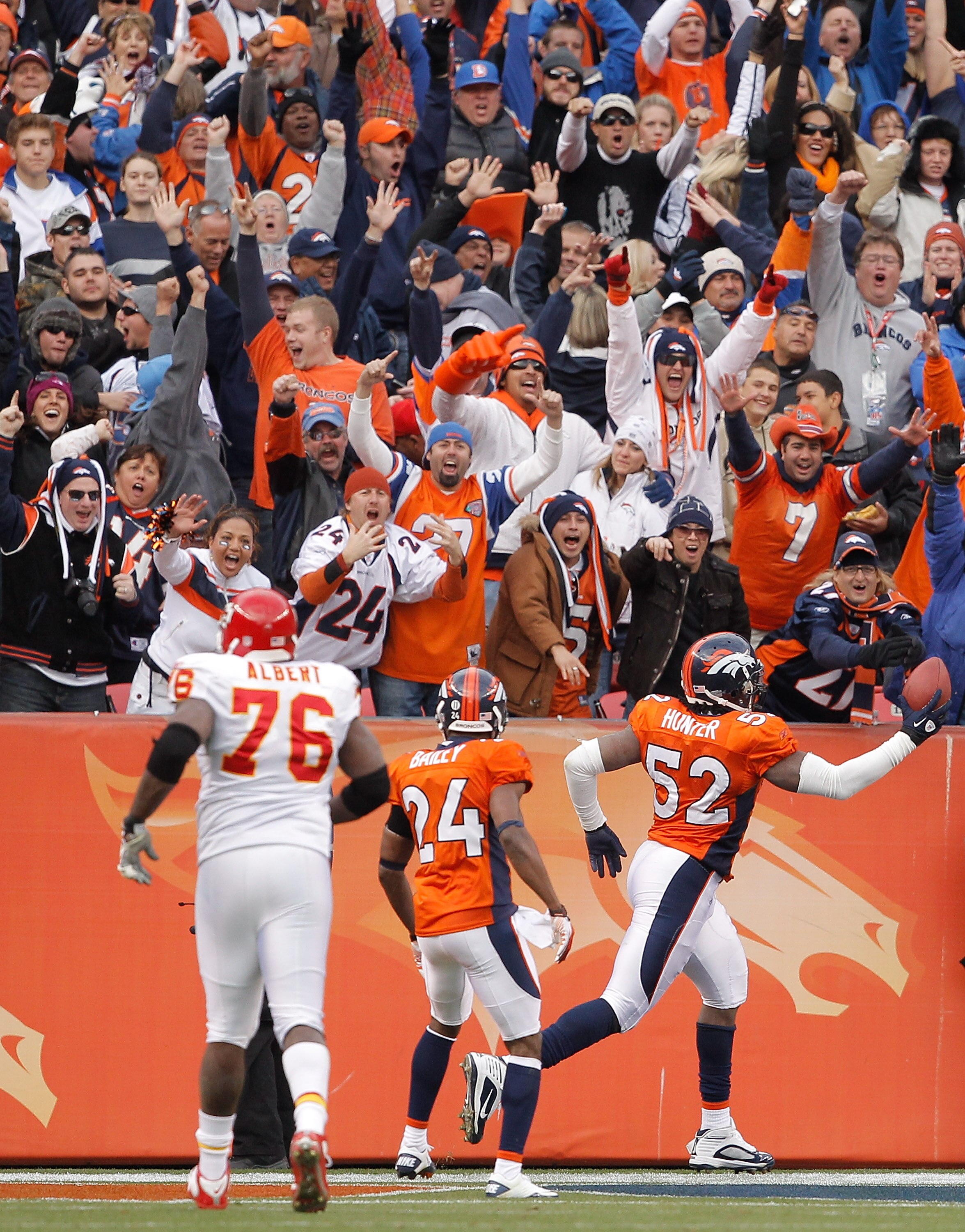 DENVER - NOVEMBER 14:  Linebacker Jason Hunter #52 of the Denver Broncos celebrates a fumble recovery and 75-yard run for a touchdown with teammate Champ Bailey #24 as offensive tackle Branden Albert #76 of the Kansas City Chiefs unsuccessfully gives chas