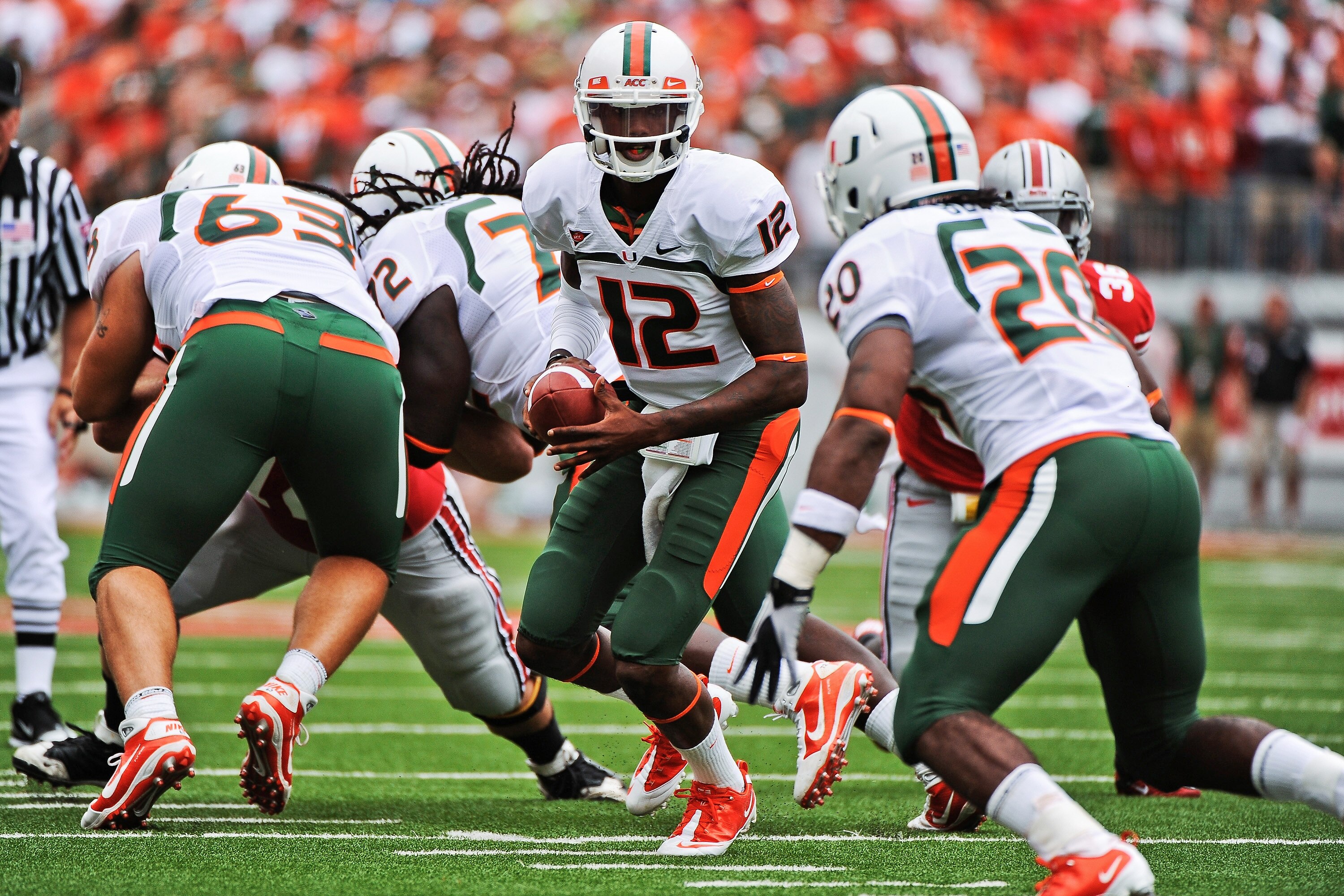 COLUMBUS, OH - SEPTEMBER 11:  Quarterback Jacory Harris #12 of the Miami Hurricanes hands the ball off to a running back against the Ohio State Buckeyes at Ohio Stadium on September 11, 2010 in Columbus, Ohio.  (Photo by Jamie Sabau/Getty Images)
